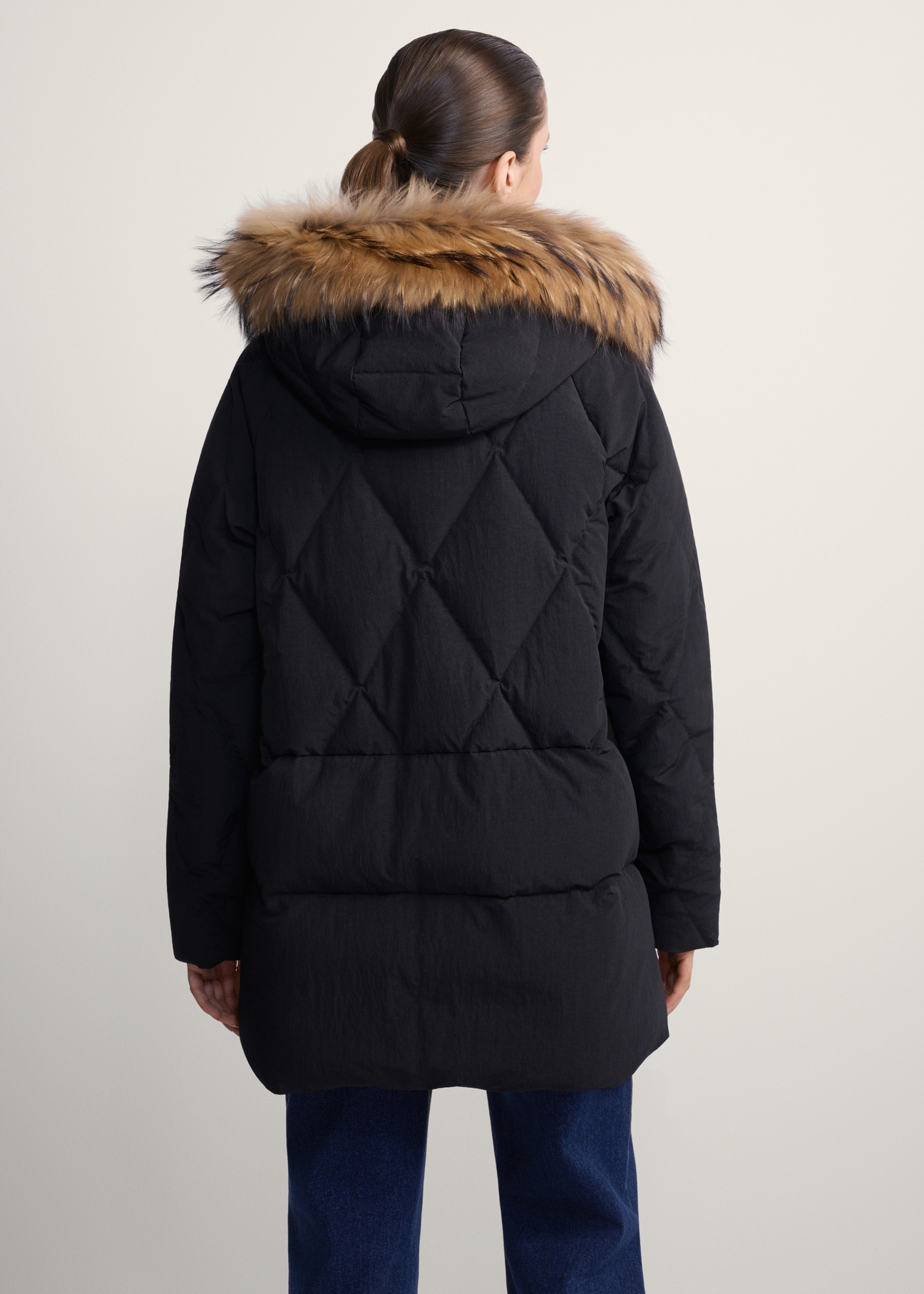 Black women's jacket with fur KURDT-0480-99(Z25), product view from the back on the model, half of the silhouette visible.