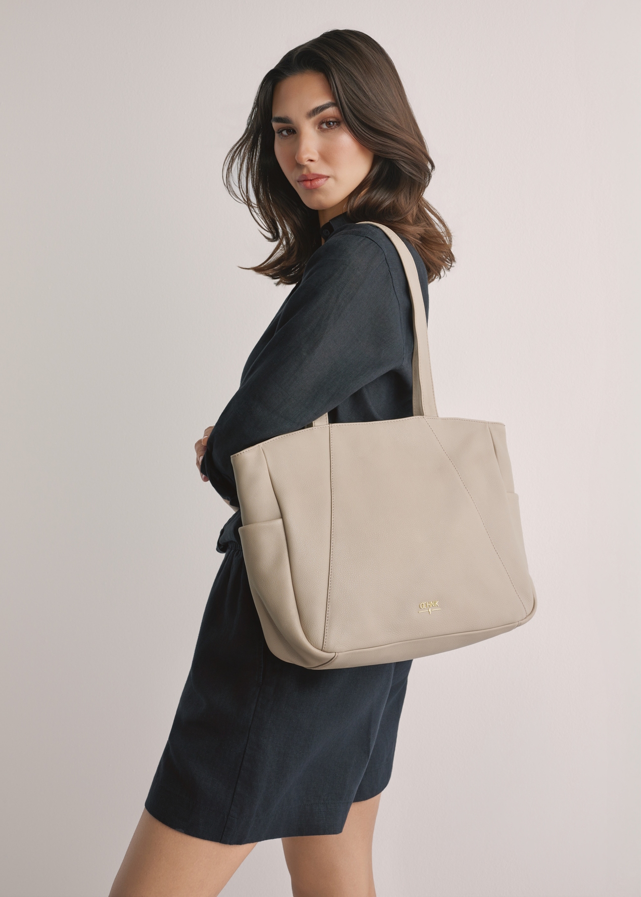 Beige leather women's shopper bag TORES-1255-1A(W26), product view on model's shoulder. Half of silhouette visible.