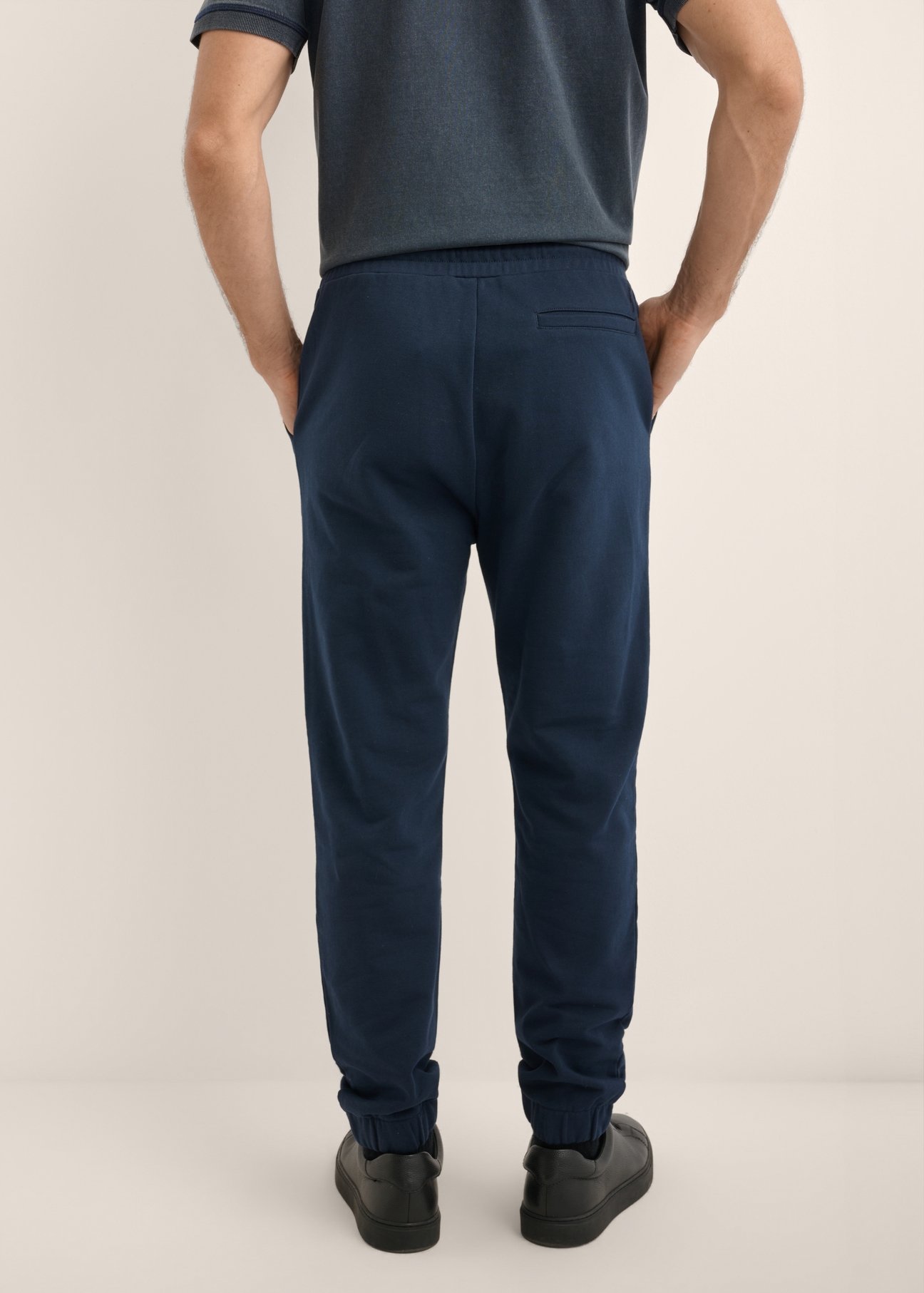 Men's navy blue sweatpants SPOMT-0128-7E(Z26), product view from the back on the model. Half of the silhouette visible.