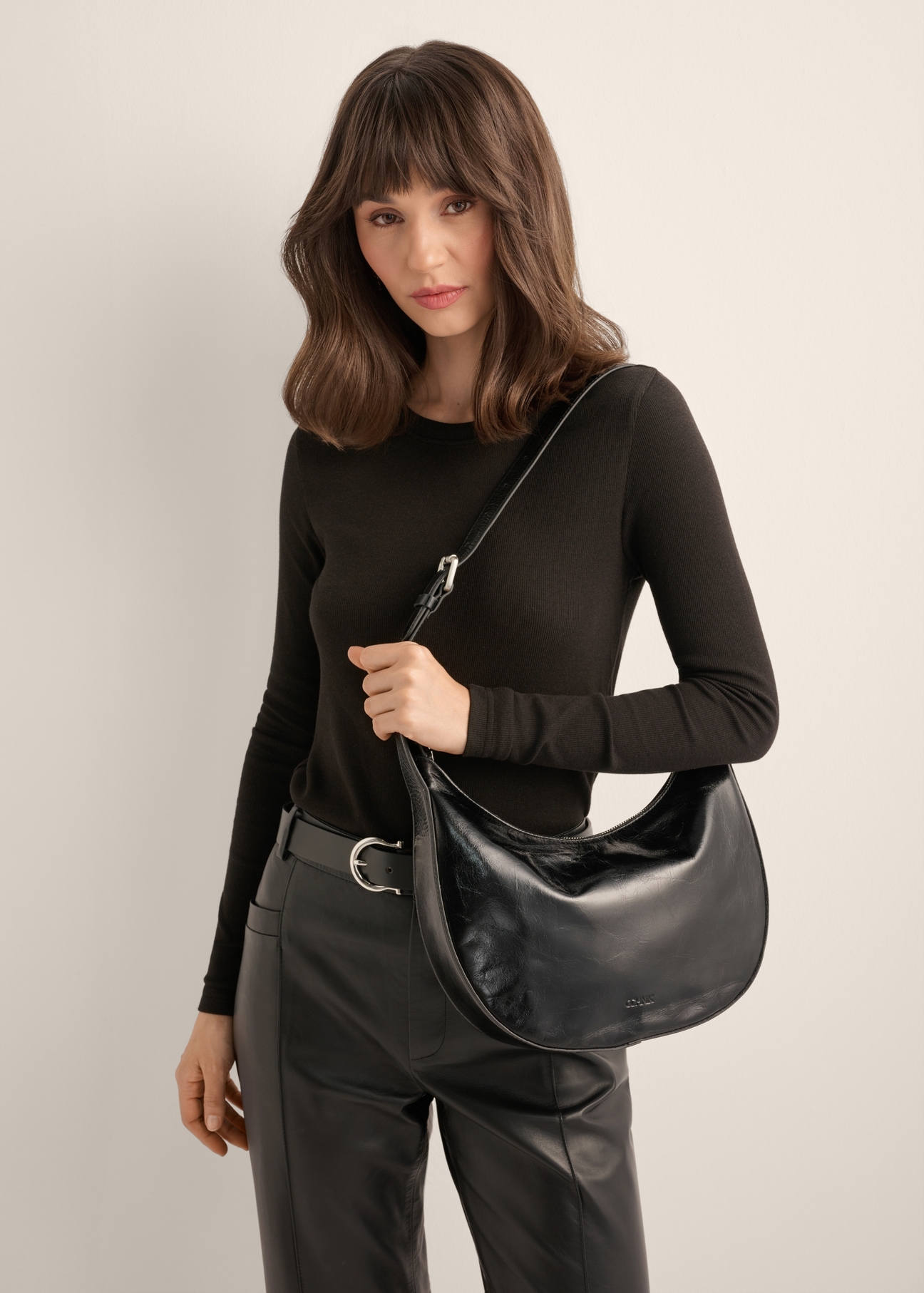 TORES-1366-9F(Z26), women's glossy hobo bag. Front view of the product on a model. Half of the silhouette visible.