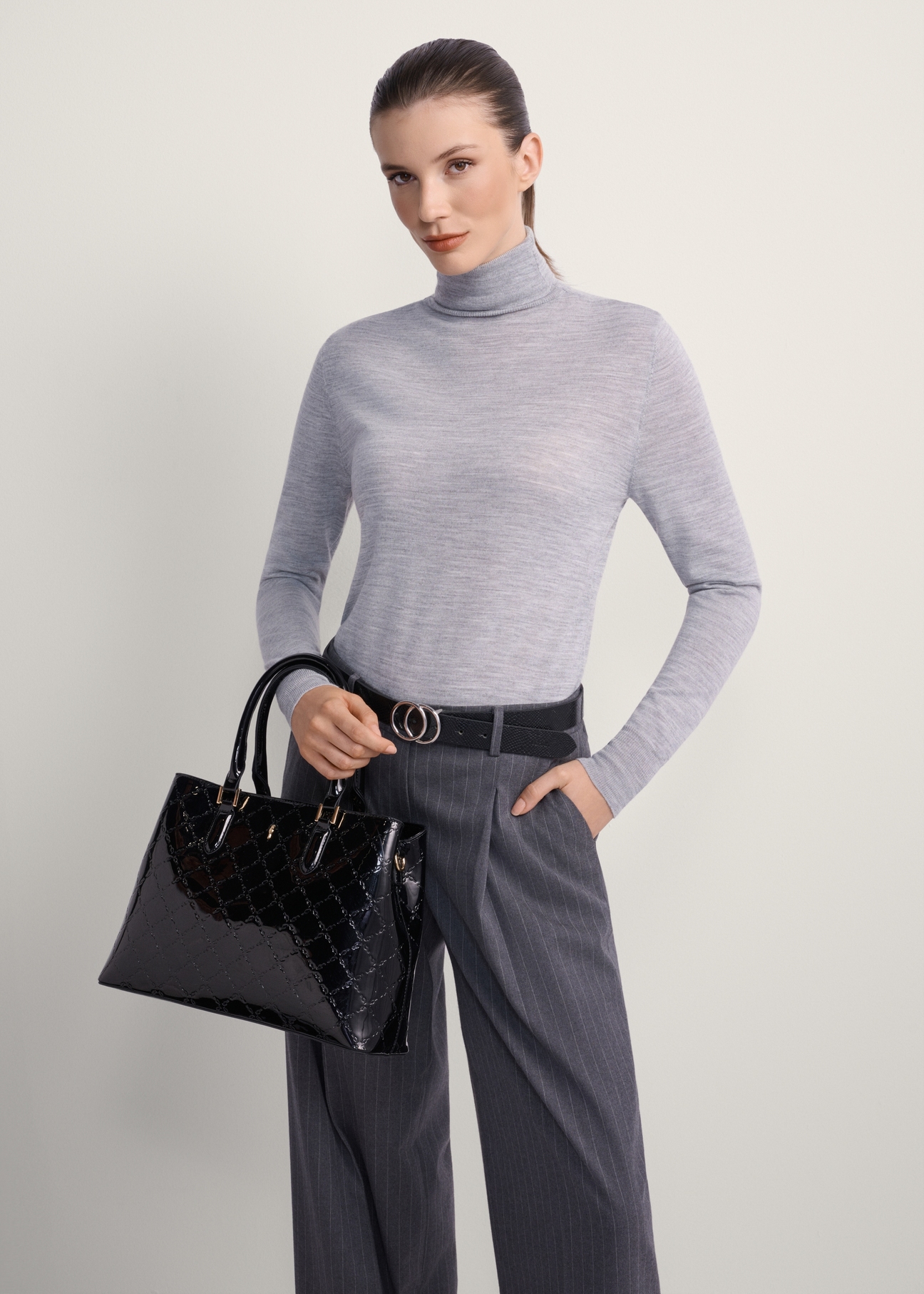 Elegant women's handbag TOREC-1111-97(Z25), front view of the product on a model, half of the silhouette visible.