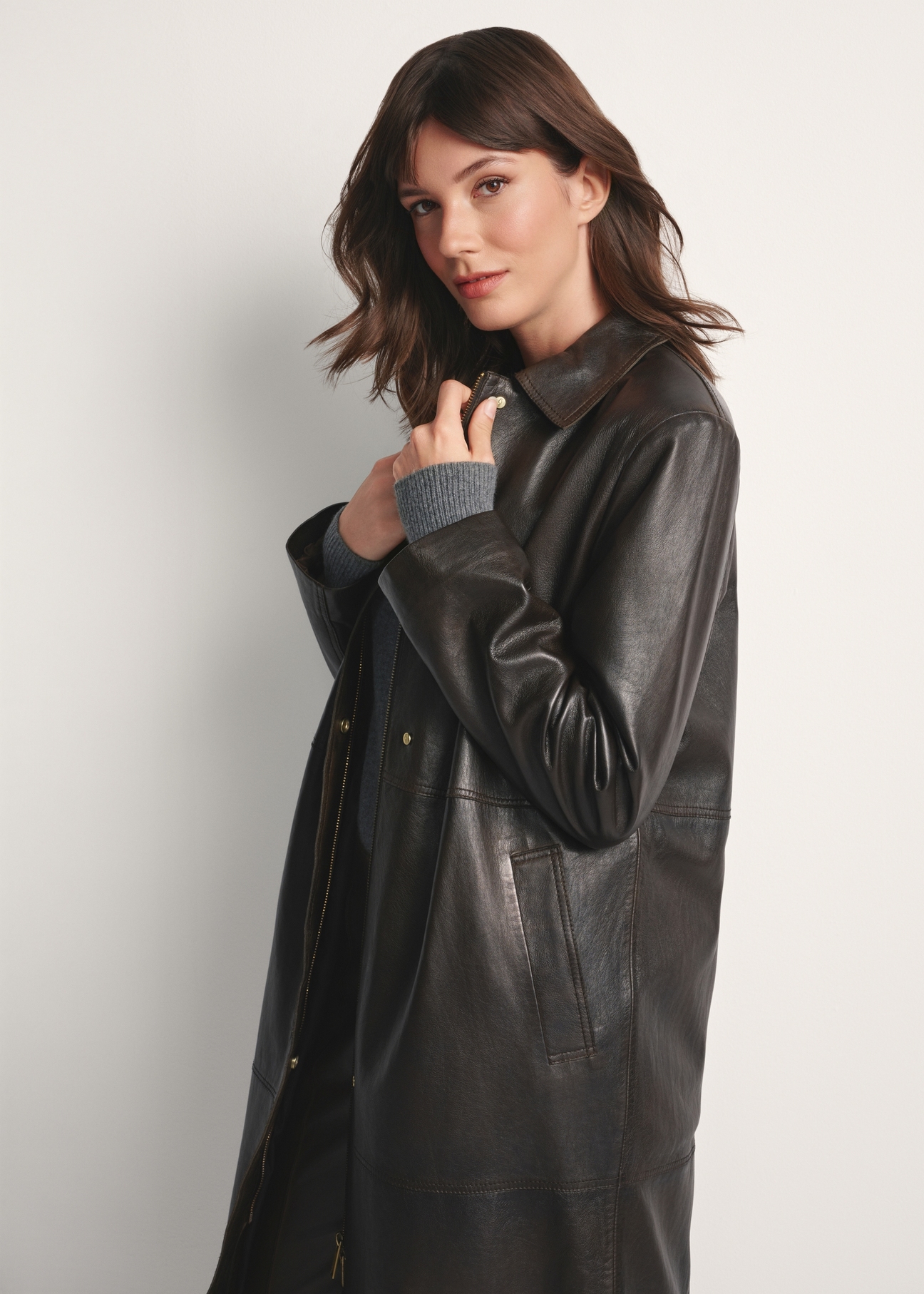 Brown long women's leather jacket KURDS-0544-2868(Z25), side view of the product on the model. Half of the silhouette visible.