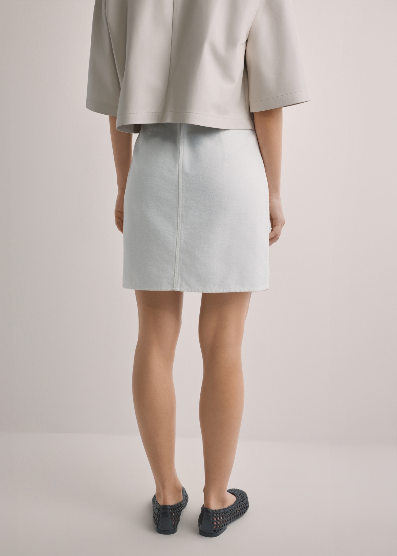 Cream denim mini skirt SPCDT-0126-0B(W26), back view of the product on the model. Half of the silhouette visible.