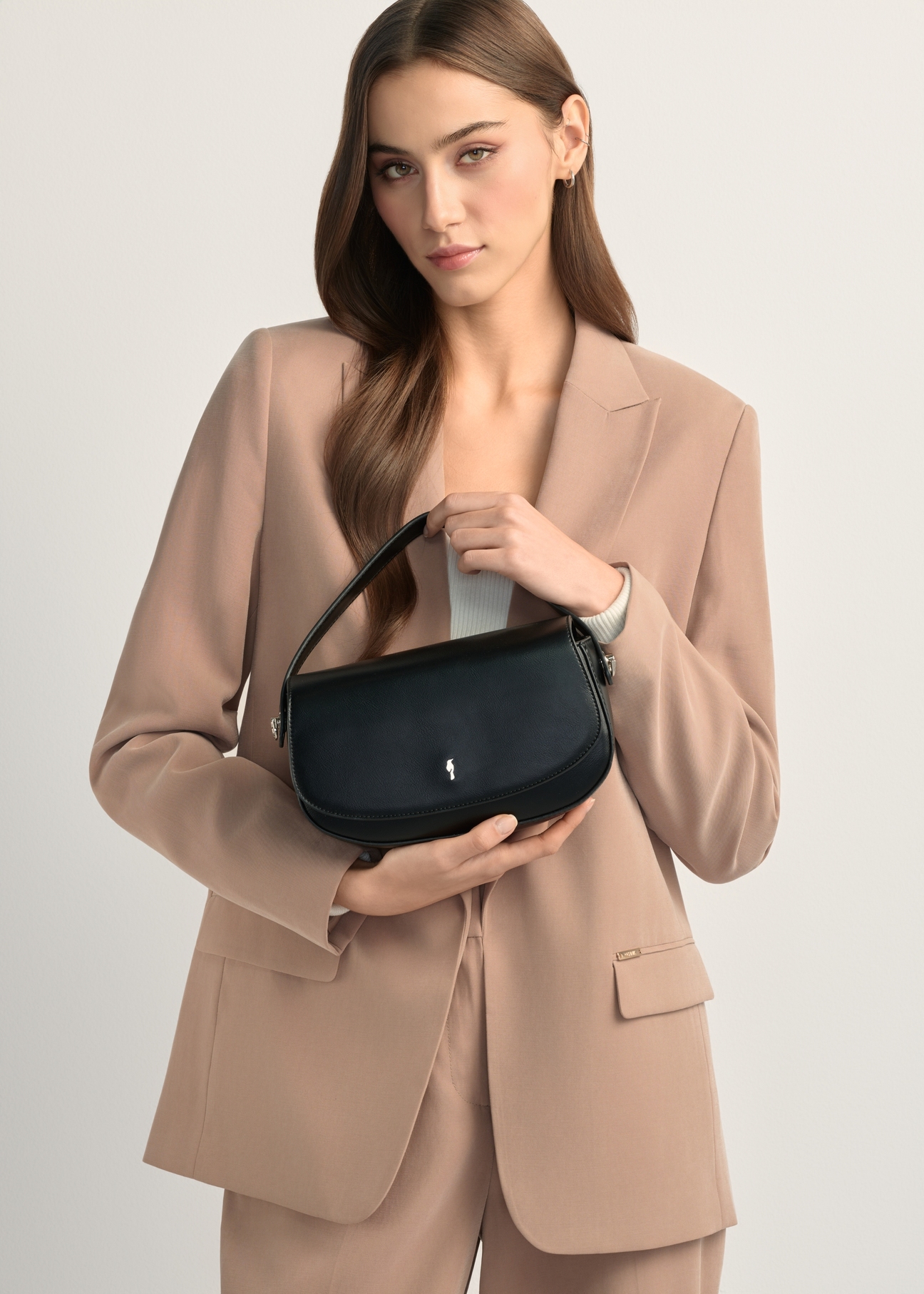 Small black women's messenger bag TOREC-1185-99(W26), product view in model's hands. Half silhouette visible.