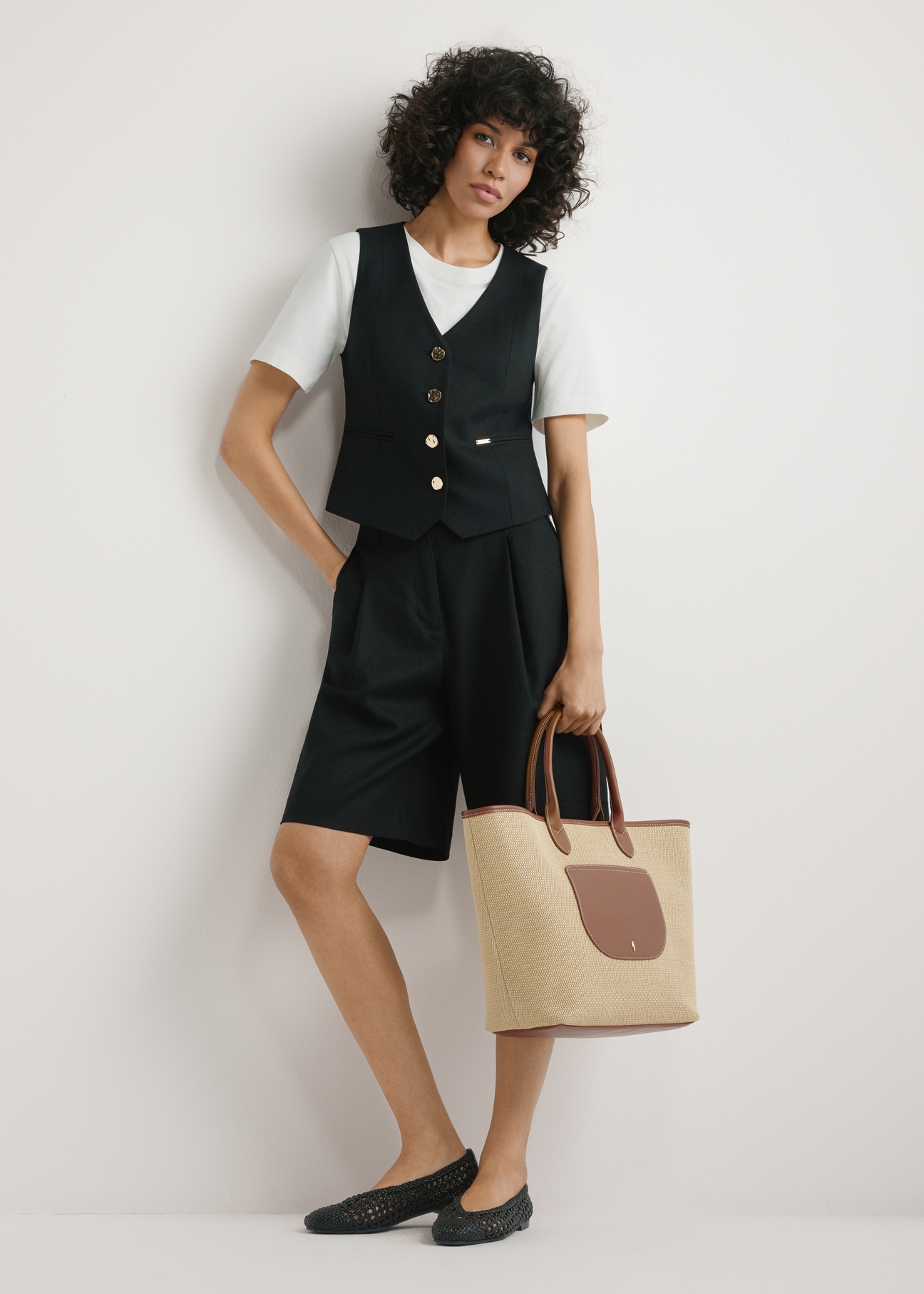Large women's straw handbag TOREC-1229-1E(W26), view of the product held in the model's hand, against a light background. The entire silhouette is visible.