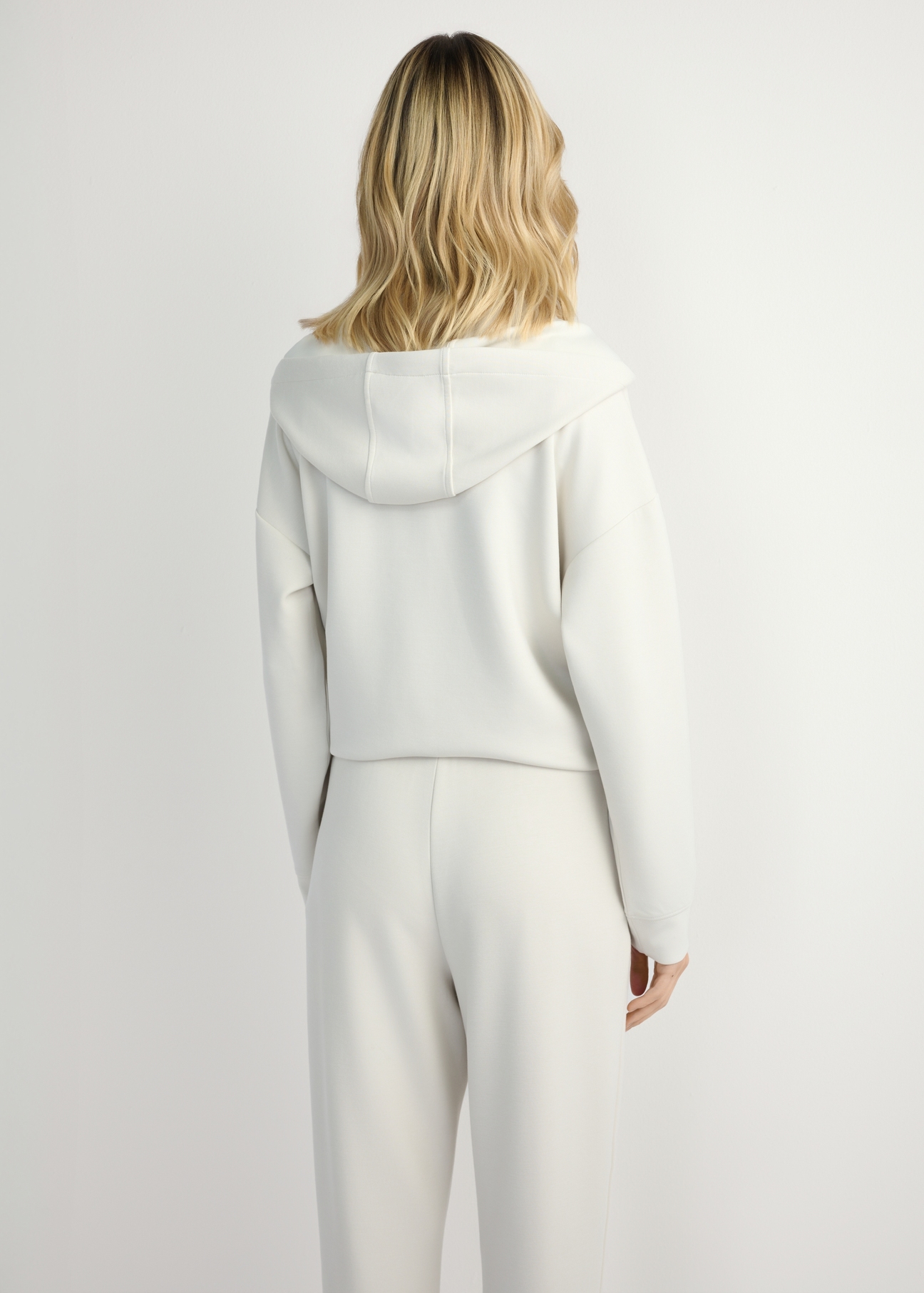 Light beige women's hooded sweatshirt BLZDT-0111A-1A(W26), back view of the product on the model. Half of the silhouette visible.