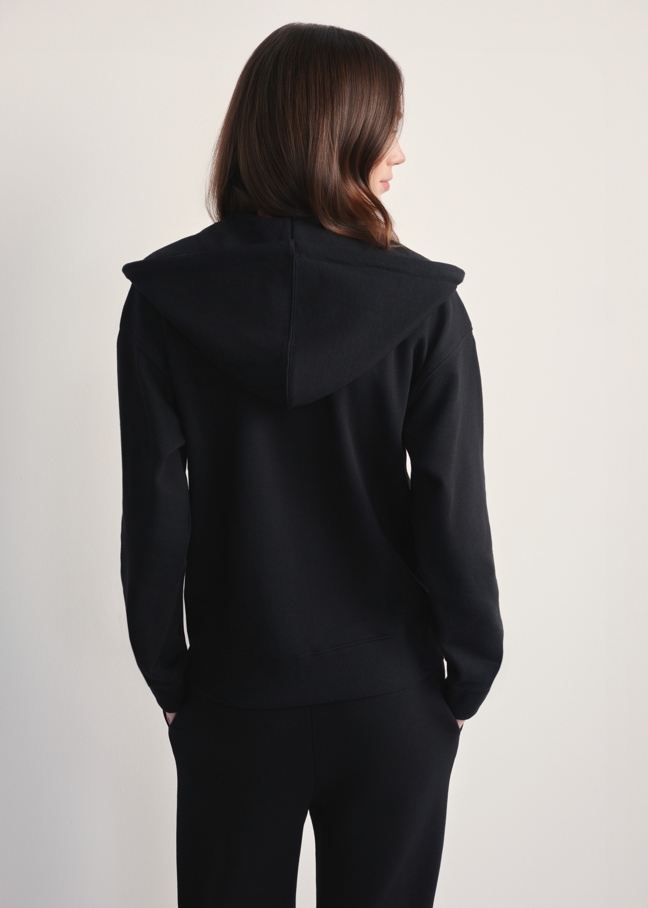 Women's black hooded sweatshirt BLZDT-0115-99(Z25), rear view of model against a light background. Half of the silhouette visible.