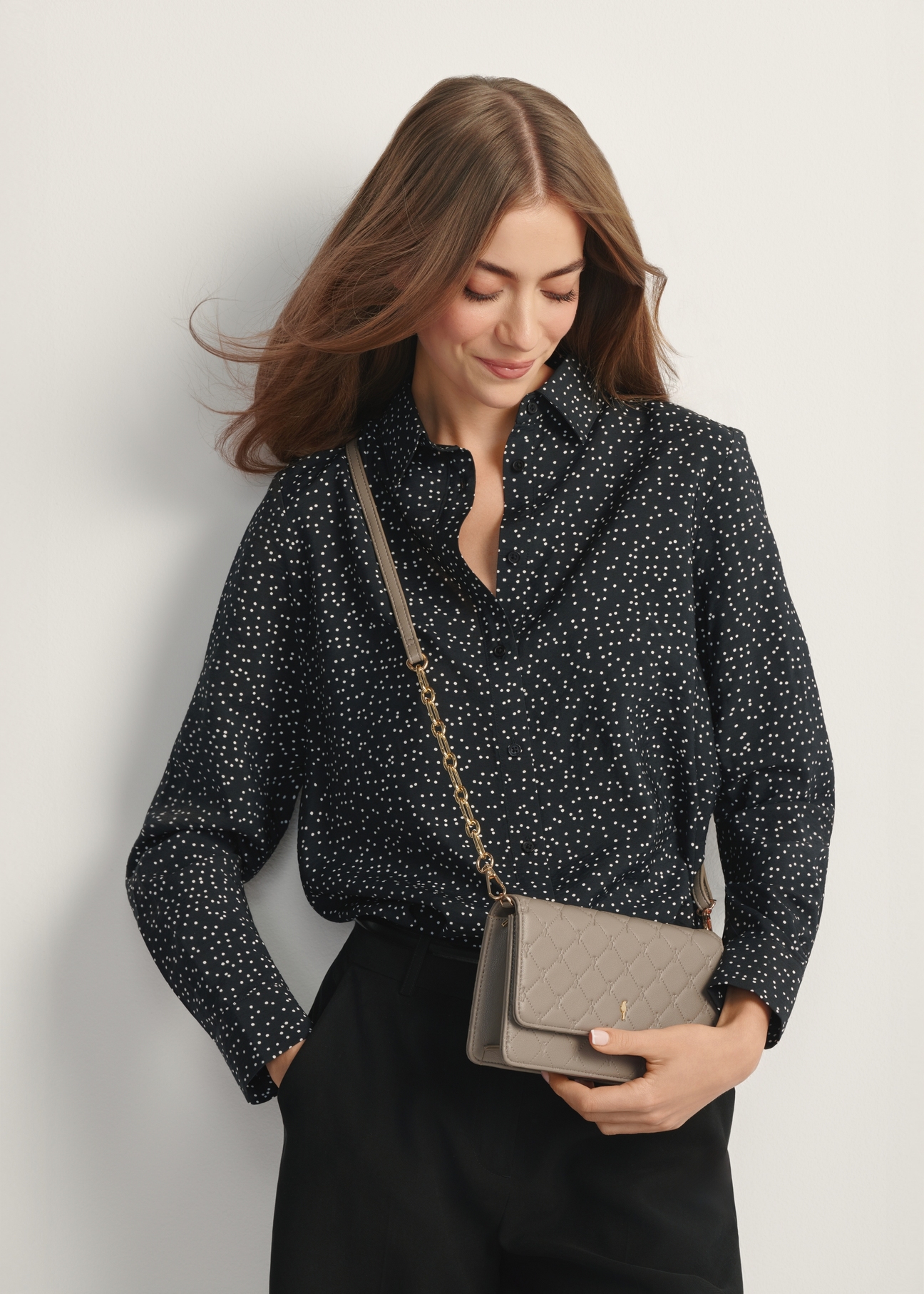 Small women's handbag in cool brown TOREC-1178-1K(W26) - front view of the product, on a model, against a light background. Half of the silhouette visible.