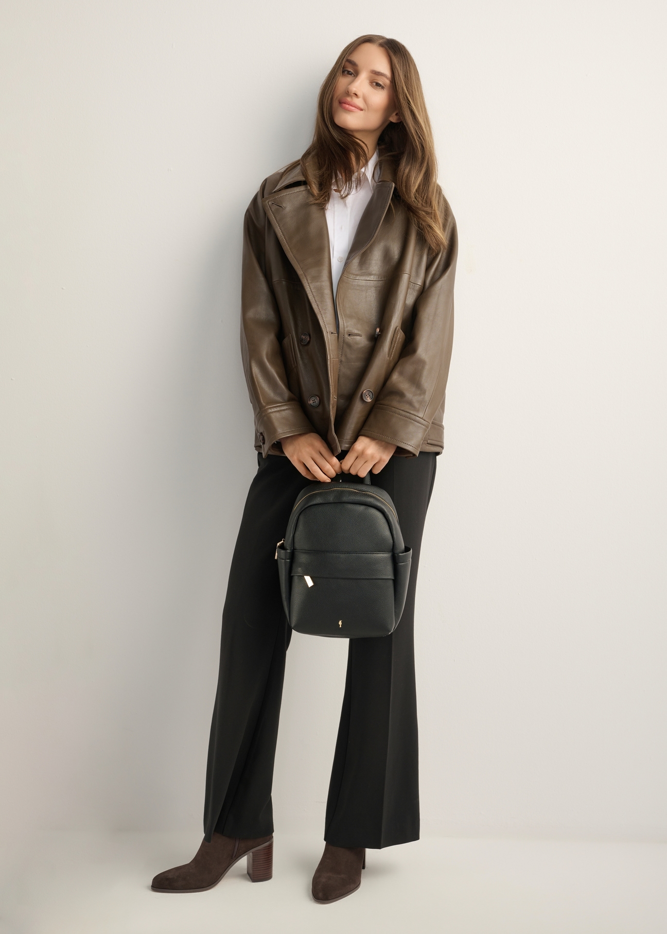 Black women's imitation leather backpack TOREC-1246-9I(Z26), front view of the product on a model. Full body view.