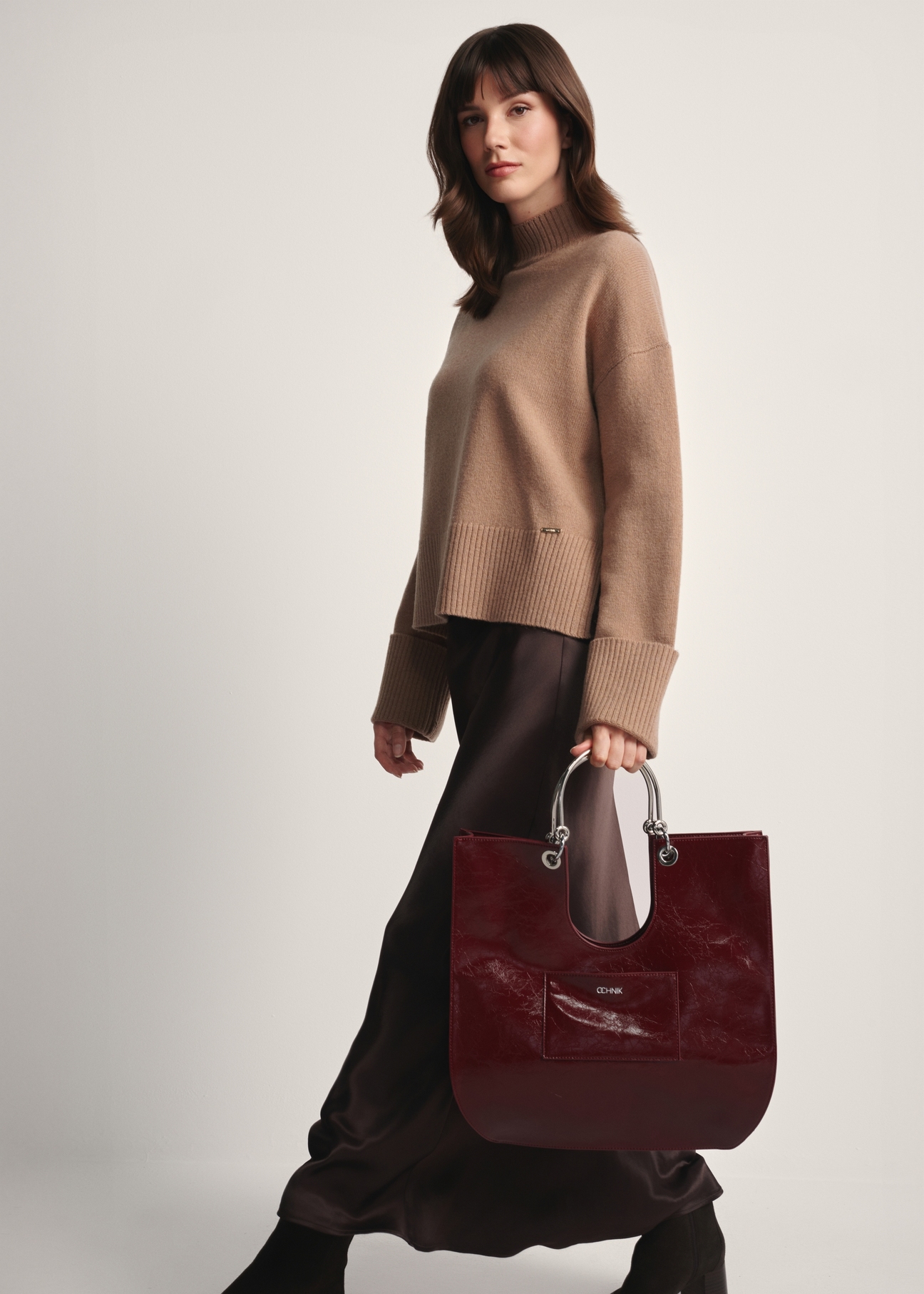 Burgundy women's handbag TOREC-0728A-49(Z25), front view of the product in the model's hand on a light background.