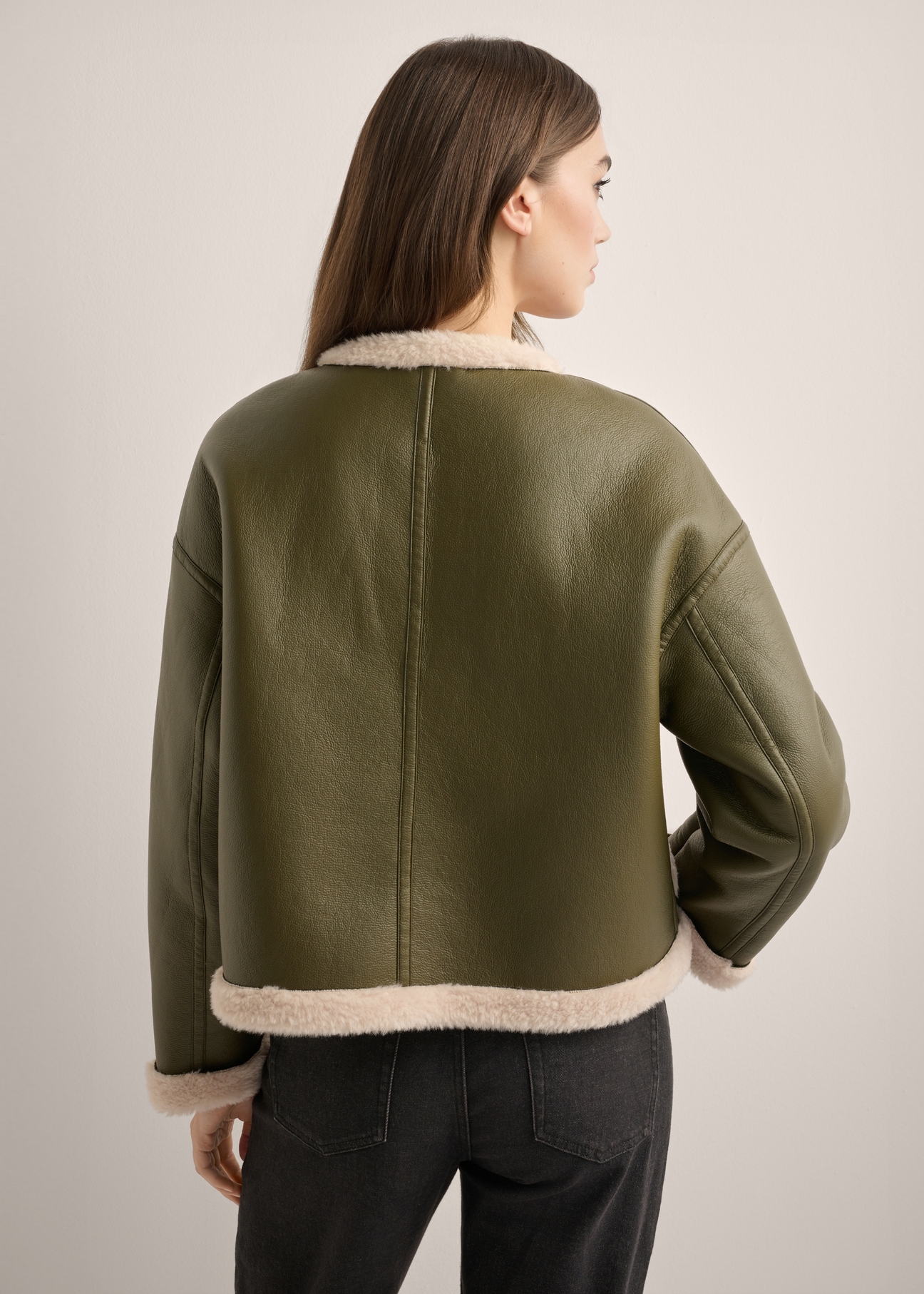 Women's short khaki sheepskin coat KOZDP-0015-8D(Z26), product view from the back on the model. Half of the silhouette visible.