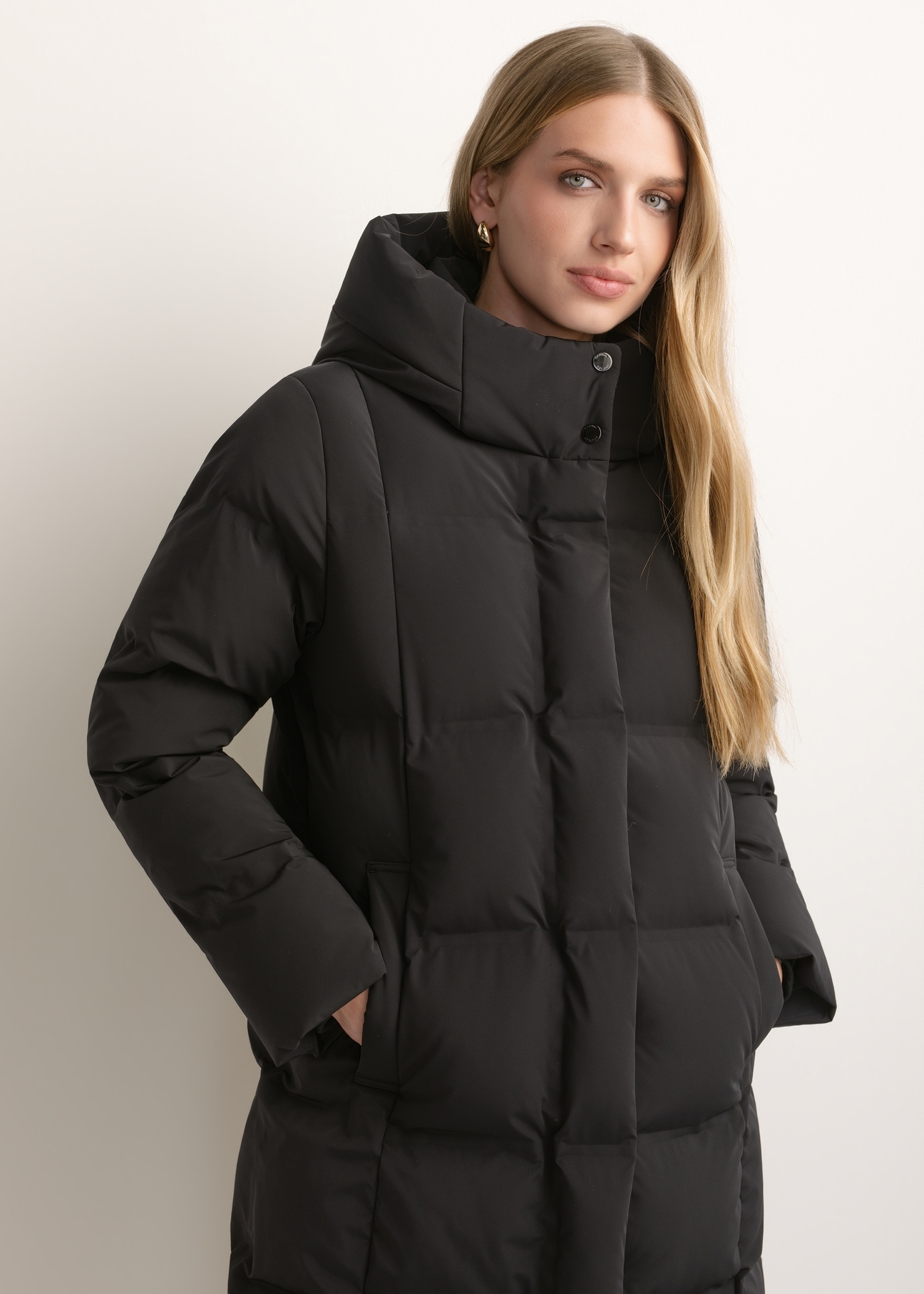 Black women's winter jacket KURDT-0699-99(Z26), front view of the product on the model. Half of the silhouette visible.