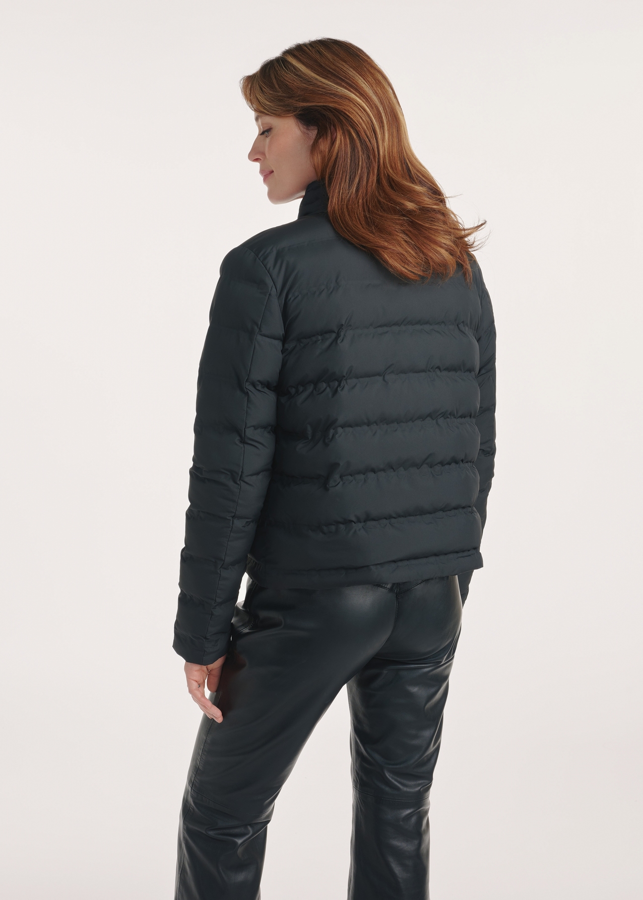Quilted black women's jacket KURDT-0495-99(Z25), product view from the back on the model, half of the silhouette visible.