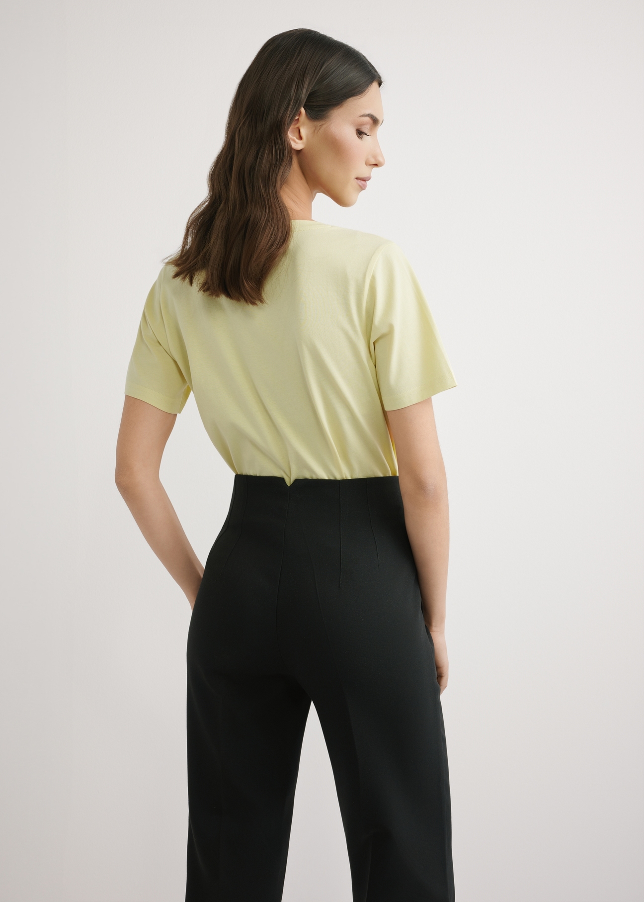 Light yellow women's basic T-shirt TSHDT-0120-2A(W26), back view of the product on the model. Half of the silhouette visible.