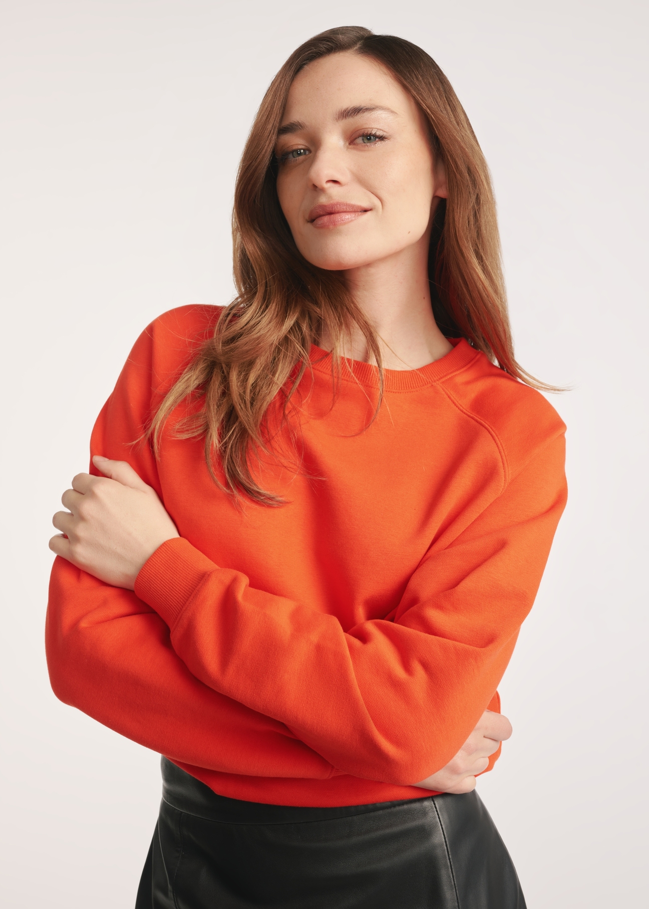 Orange women's sweatshirt BLZDT-0114-30(Z25) - close-up of the product on a model on a white background. Half of the silhouette visible.