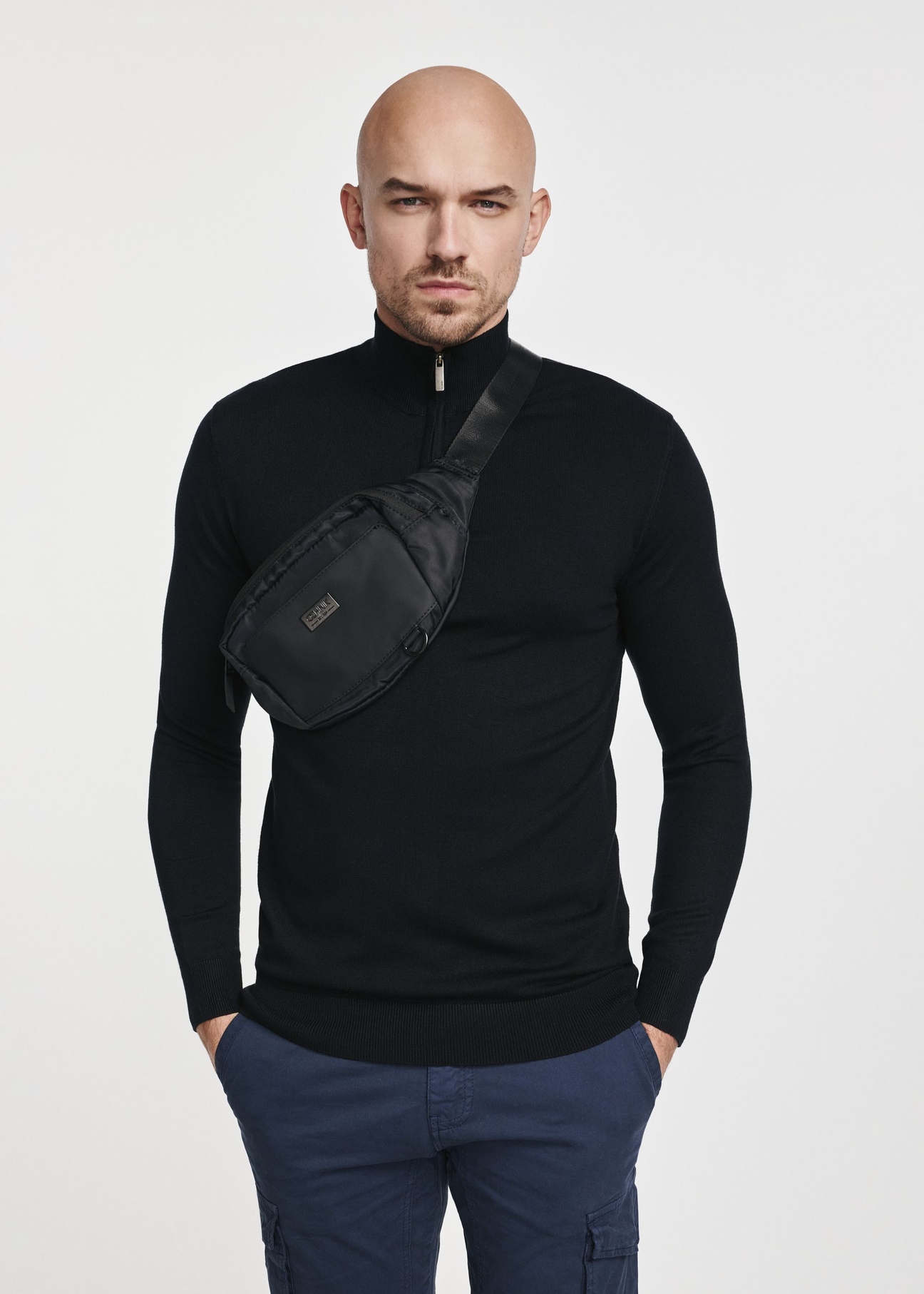 Black men's waist bag TORMN-0315B-99(Z25), product view of a model against a light background. Half of the silhouette visible.