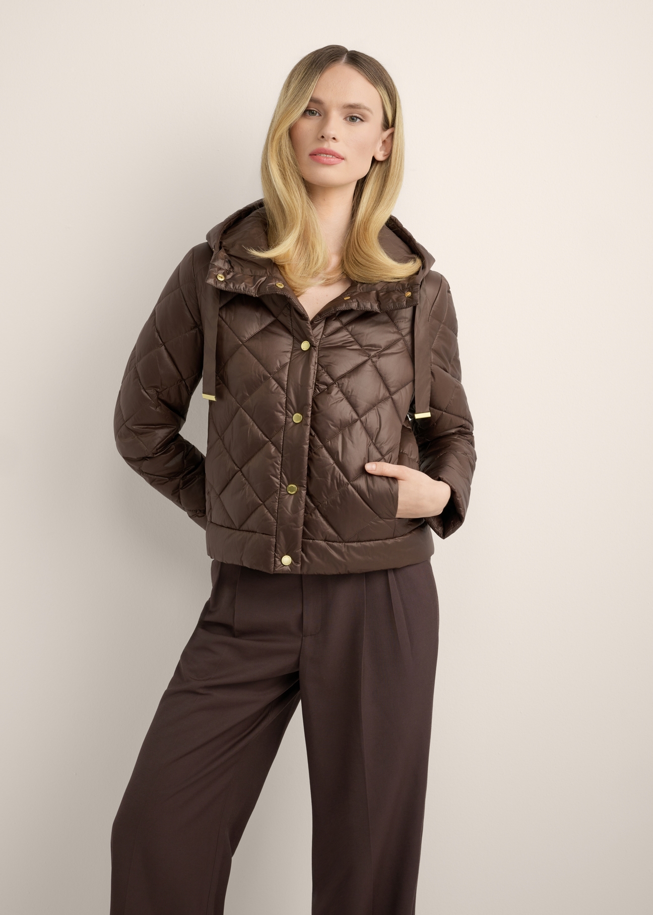 Women's brown short quilted jacket KURDT-0678-1H(Z26), front view of the product on the model. Half of the silhouette visible.