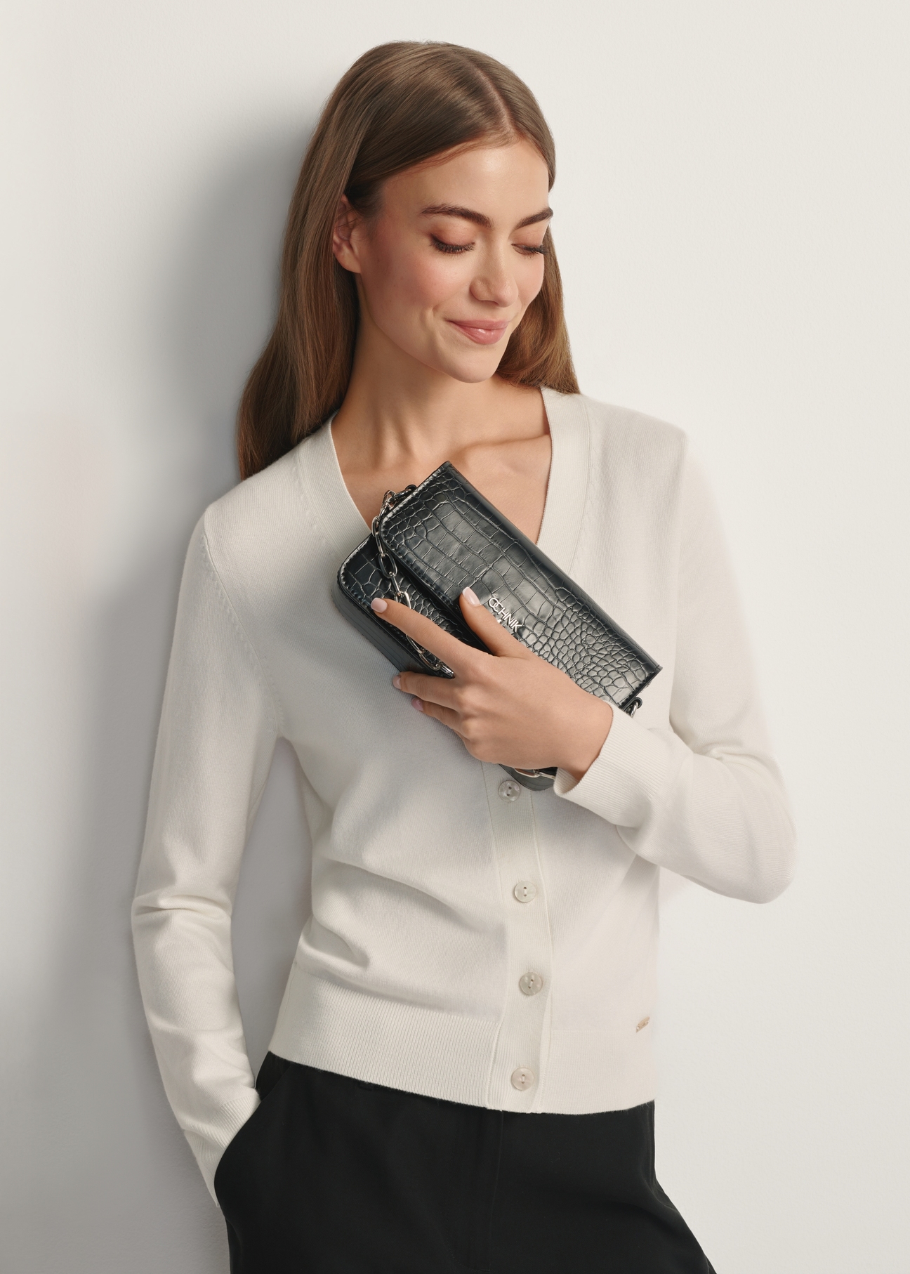 Small women's croco handbag TOREC-1171-9G(W26) - front view of the product, held by the model, against a light background. Half of the silhouette visible.