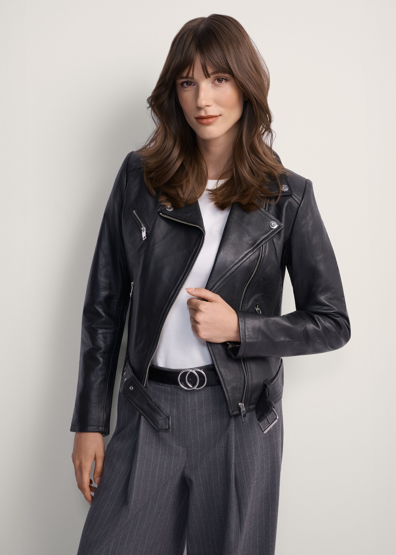 Women's leather biker jacket KURDS-0274-99(KS), front view of the product on the model. Half of the silhouette visible.