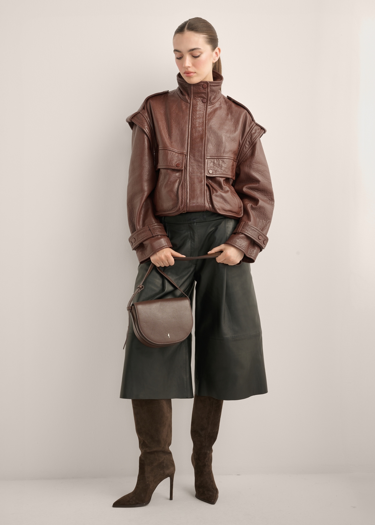 Women's brown leather messenger bag TORES-1352-1H(Z26), diagonal view of the product on the model. Full body visible.