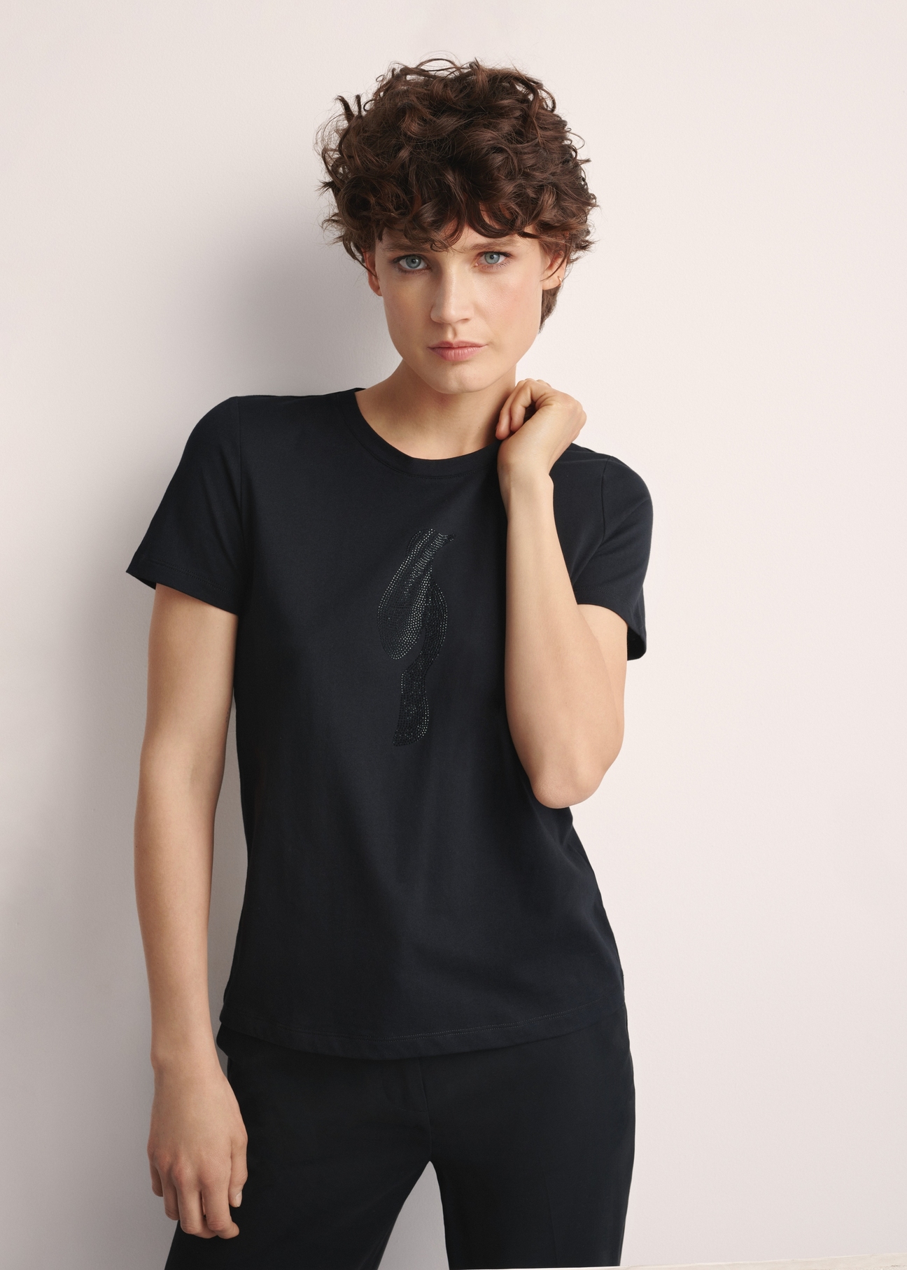 Black women's T-shirt with logo TSHDT-0148-99(Z25), front view of the product on the model. Half of the silhouette visible.