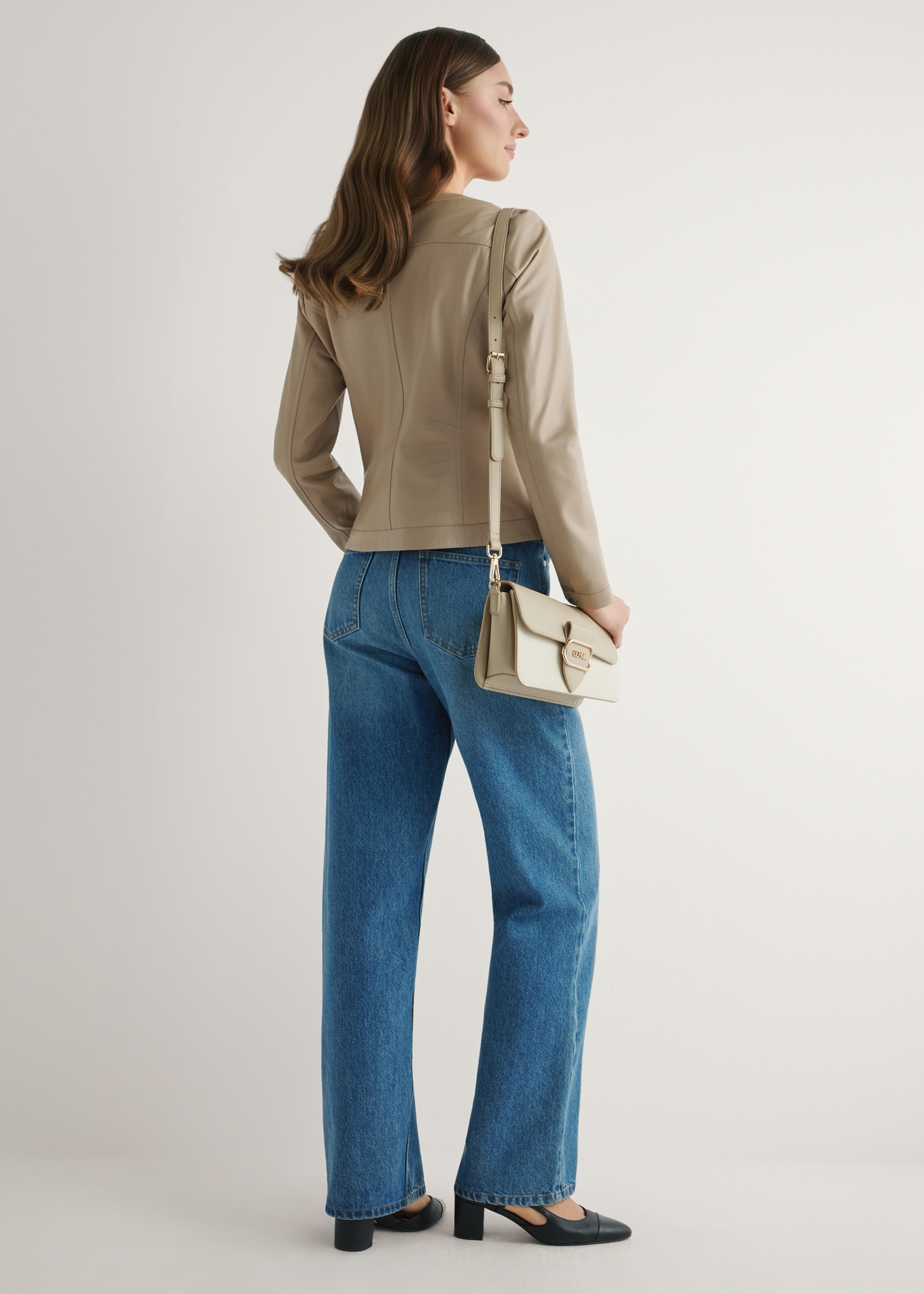 Cream women's messenger bag TOREC-1120-0P(W26) - product view slightly diagonal, on a model, against a light background. The entire silhouette is visible.