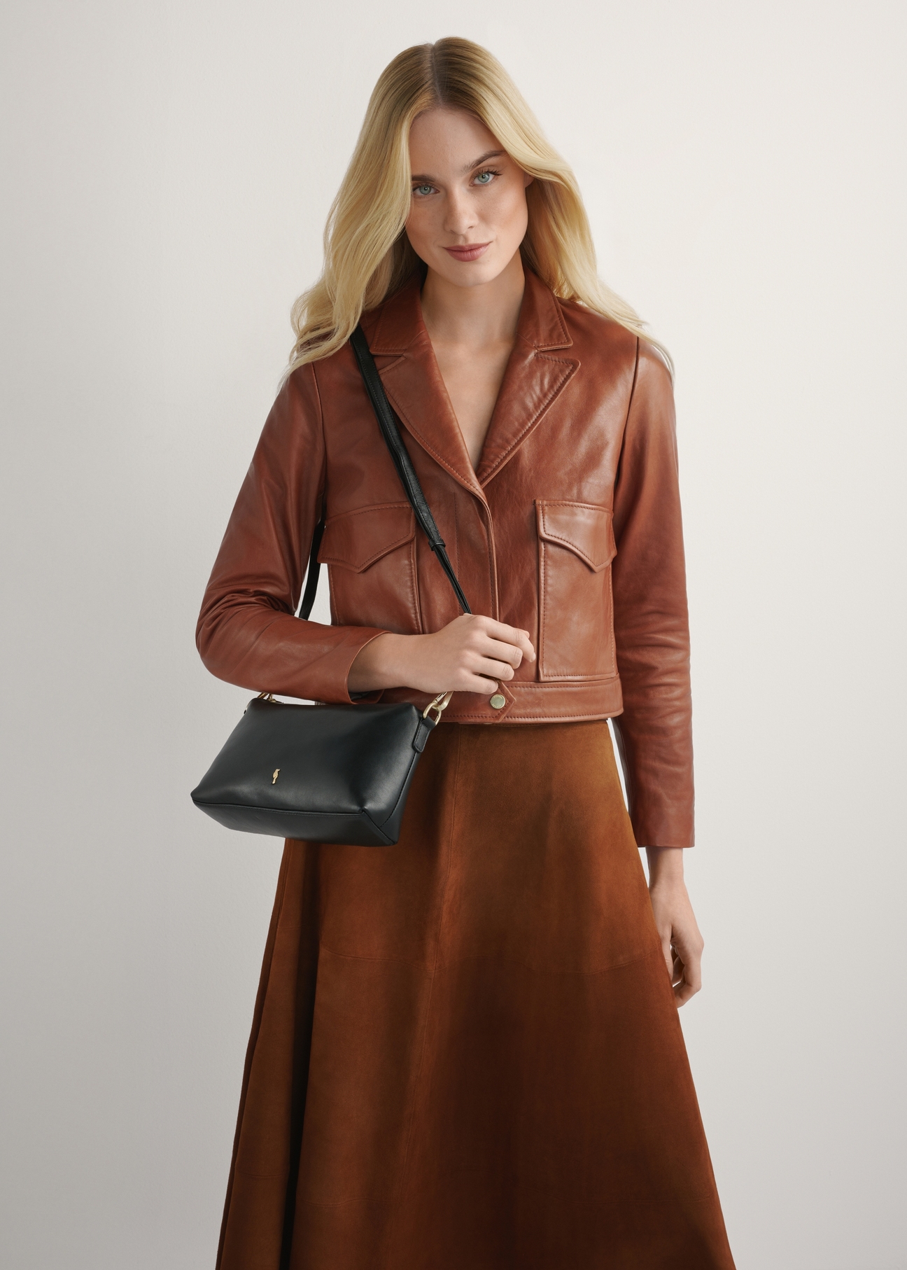 Small black leather women's handbag TORES-1241-99(W26), product view on model's shoulder. Half of silhouette visible.