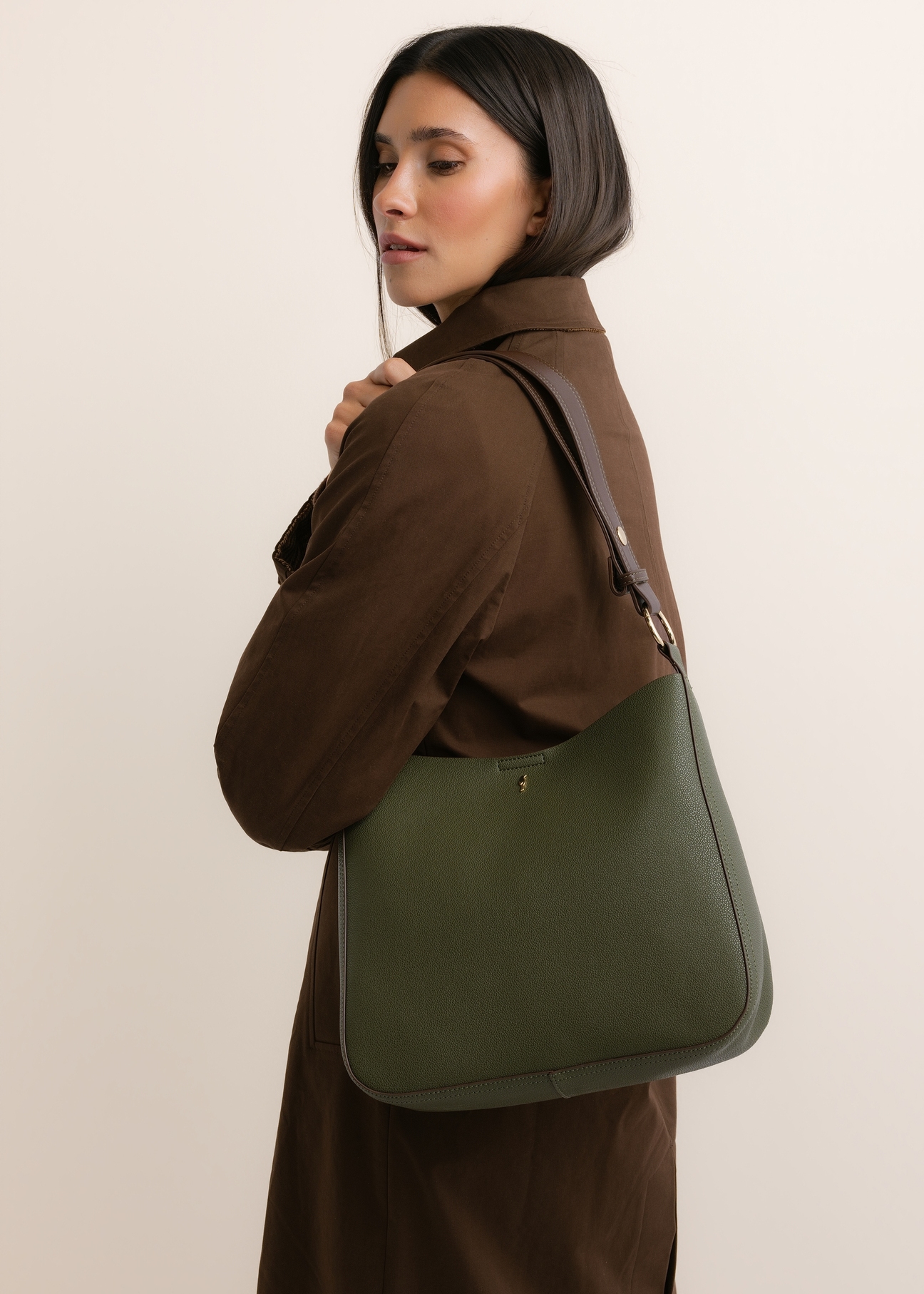 Green women's hobo bag TOREC-1257-8B(Z26), diagonal view of the product, on a model, on a light background. Half of the silhouette visible.