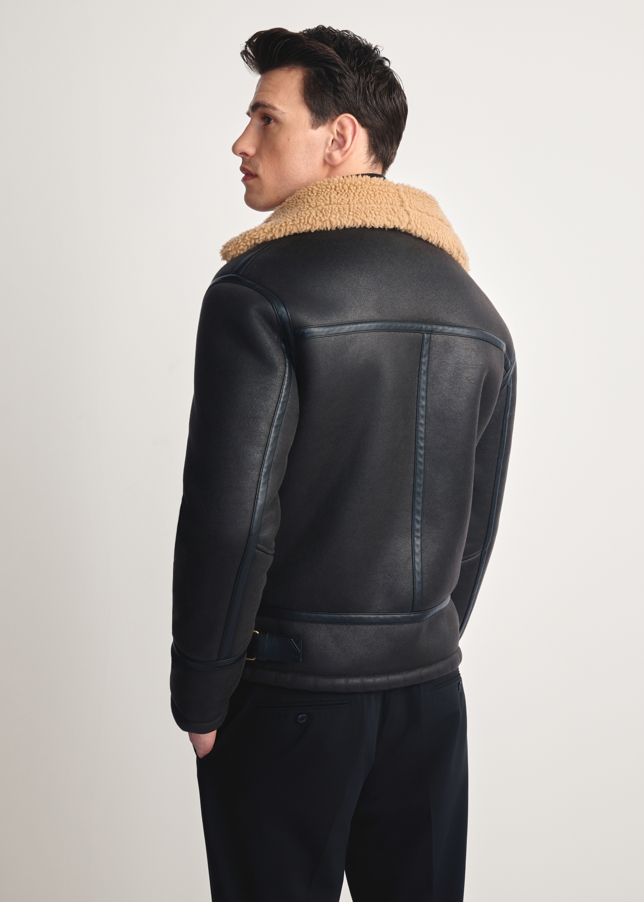 Dark brown men's sheepskin coat KOZMP-0002-90(Z25), product view from the back on the model, half of the silhouette visible.