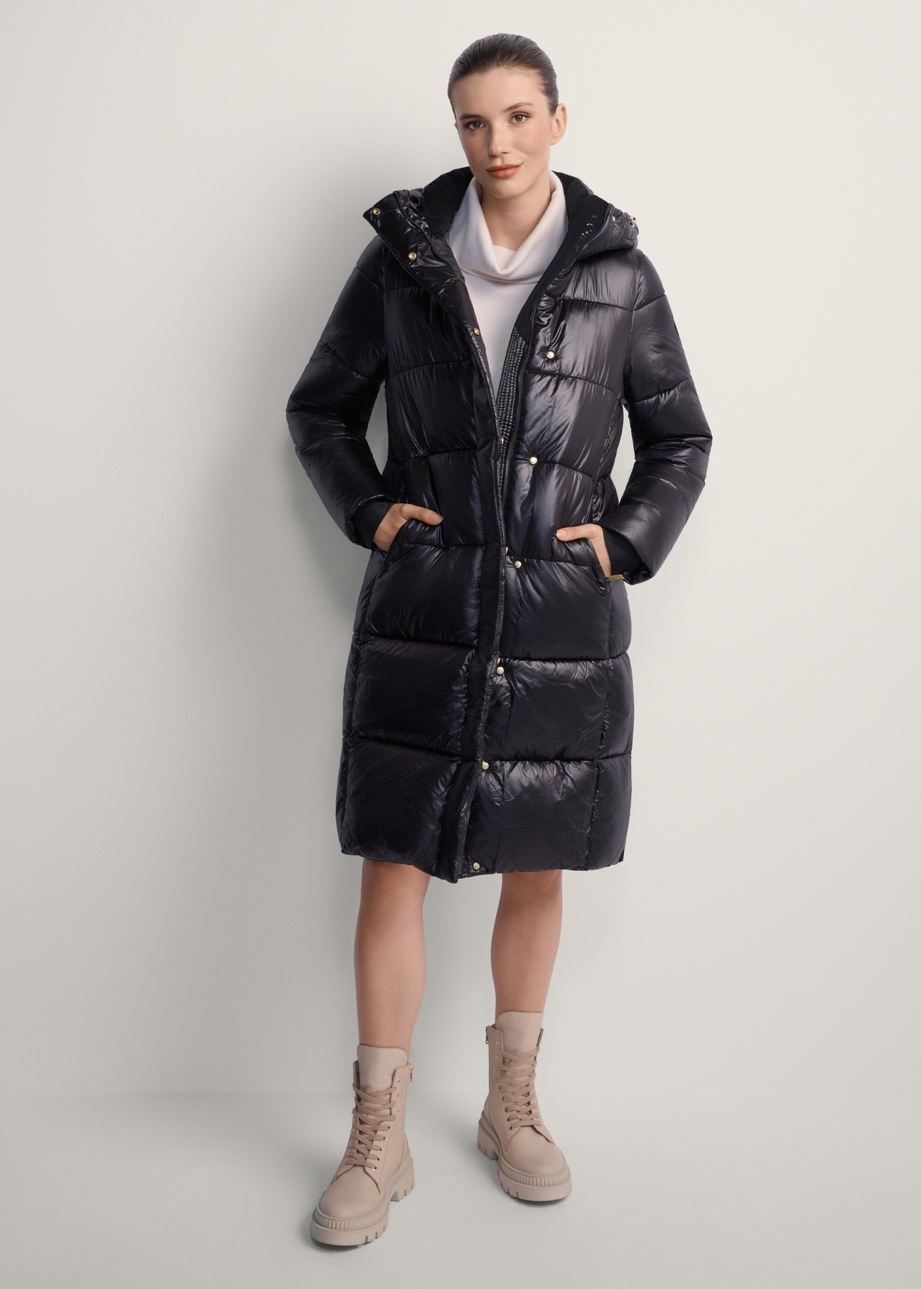 Black long women's winter jacket KURDT-0531A-99(Z25), product view from the front on the model, the whole silhouette is visible.