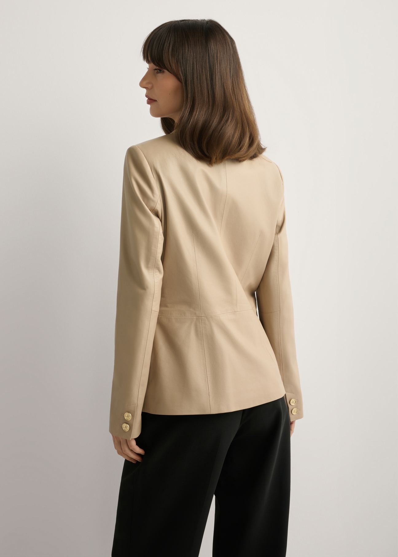 Beige women's leather jacket KURDS-0445-1B(W26), back view of the product on the model. Half of the silhouette visible.