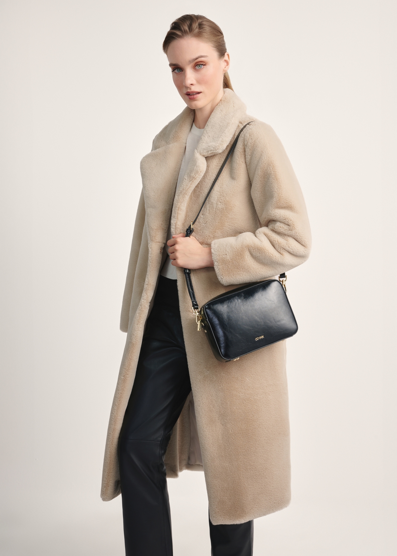 Black women's handbag TOREC-0003J-98(Z25), product view on model's shoulder. Part of the silhouette visible.