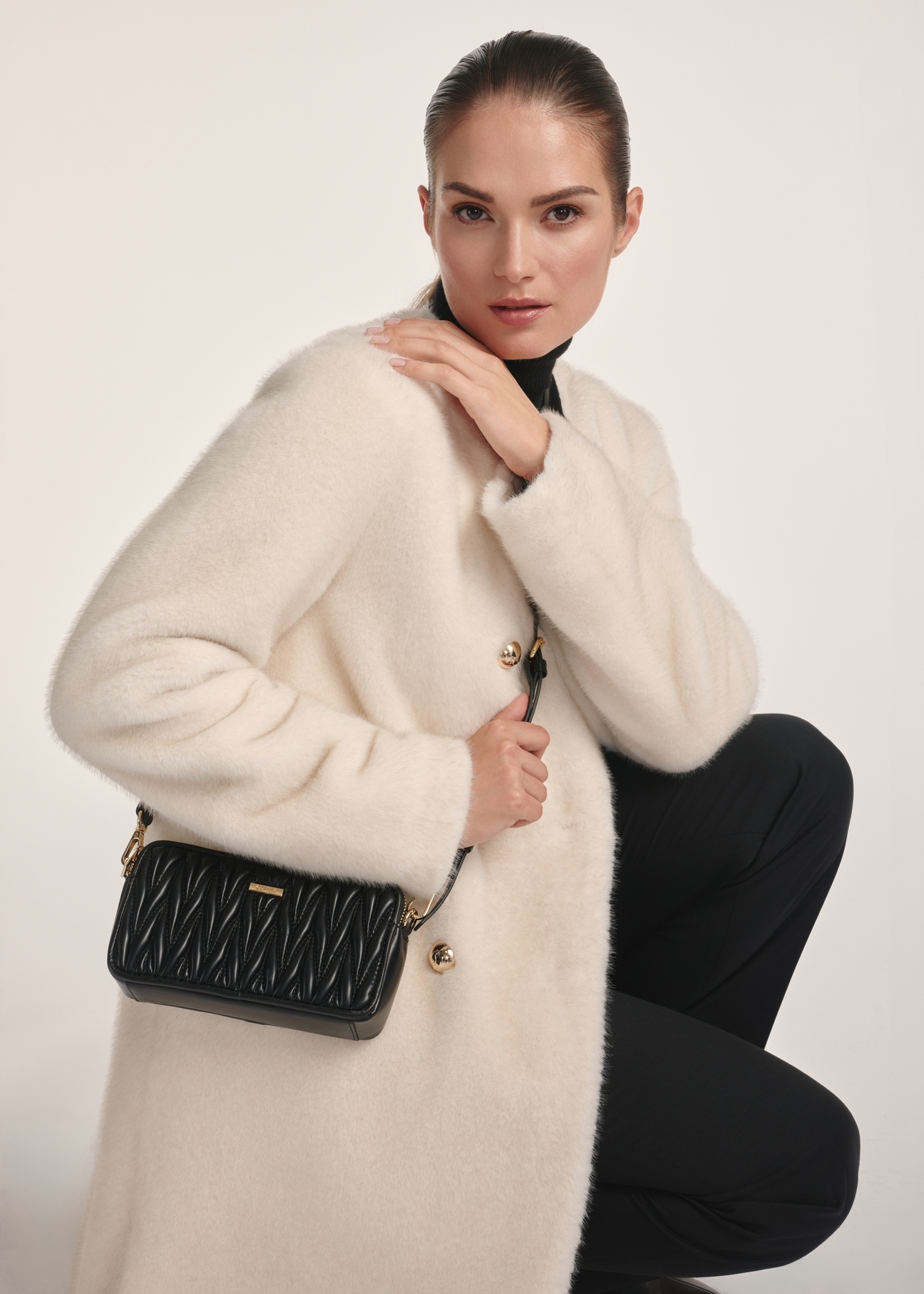 Classic black women's handbag TOREC-1103-99(Z25) - front view of the product on a model against a white background. Half of the silhouette visible.