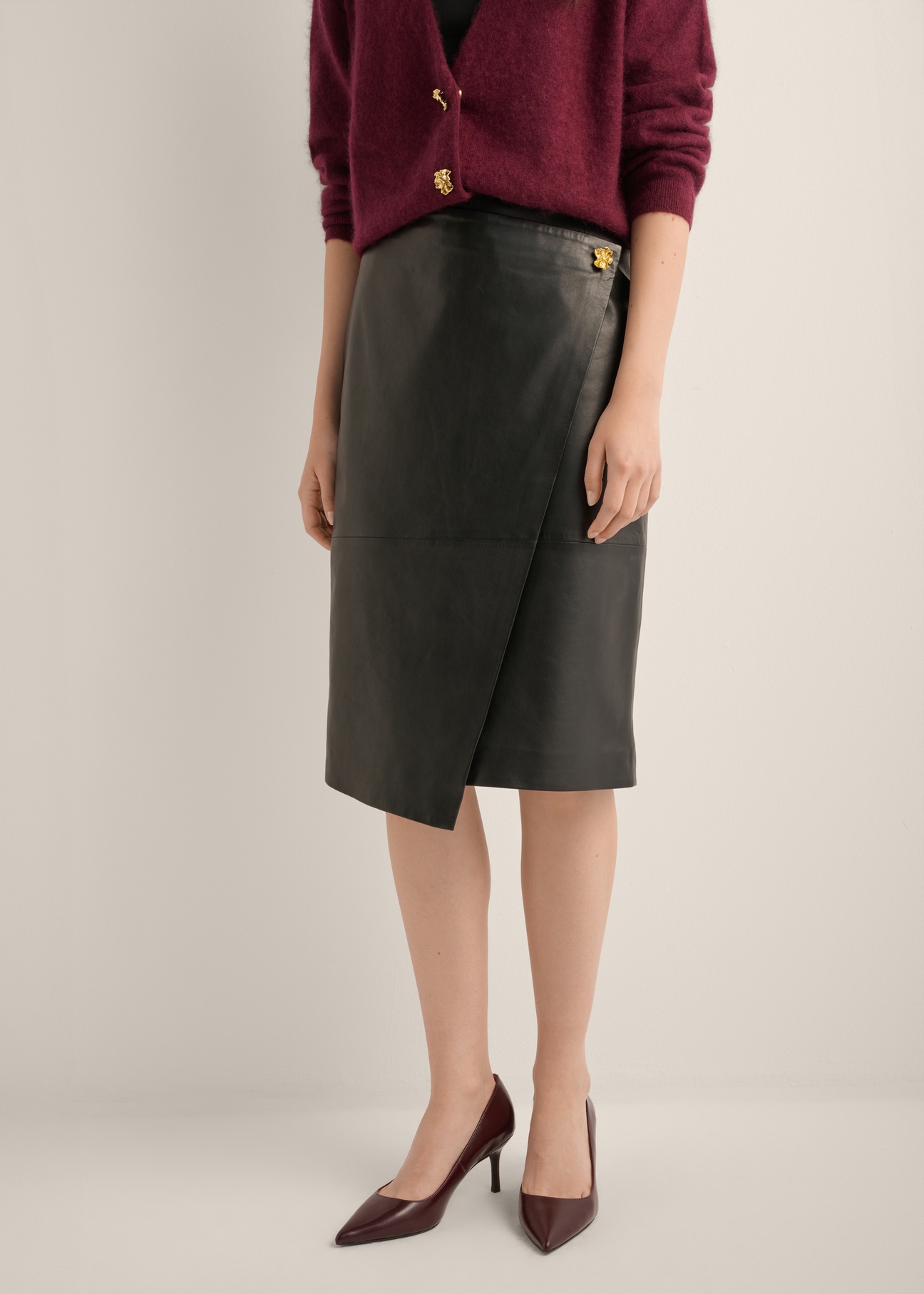 Black leather skirt with embellishment SPCDS-0085-99(Z26), front view of the product on the model. Half of the silhouette visible.
