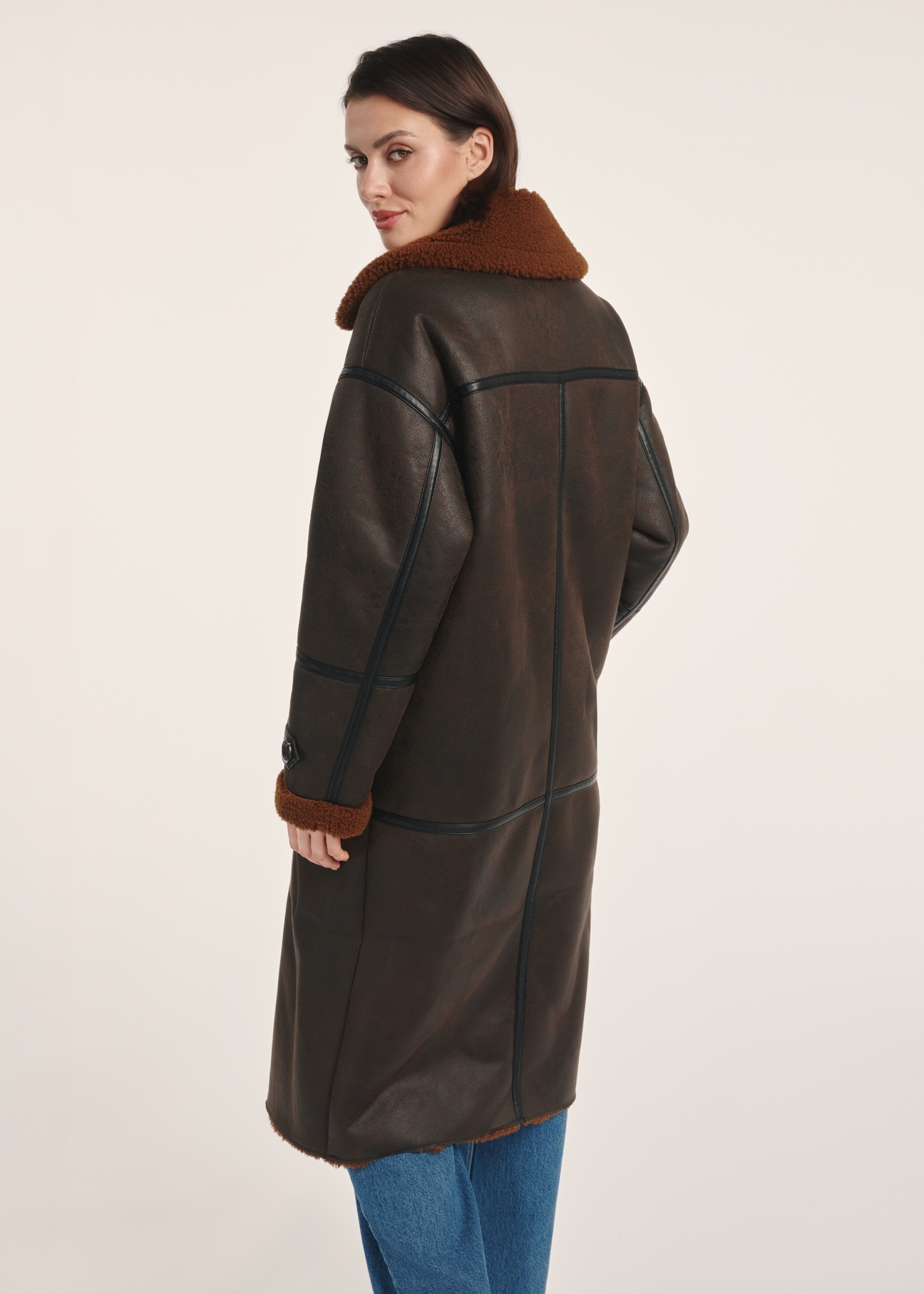 Long brown women's sheepskin coat KOZDP-0014-90(Z25) - product view from the back on a model on a white background. The entire silhouette is visible.