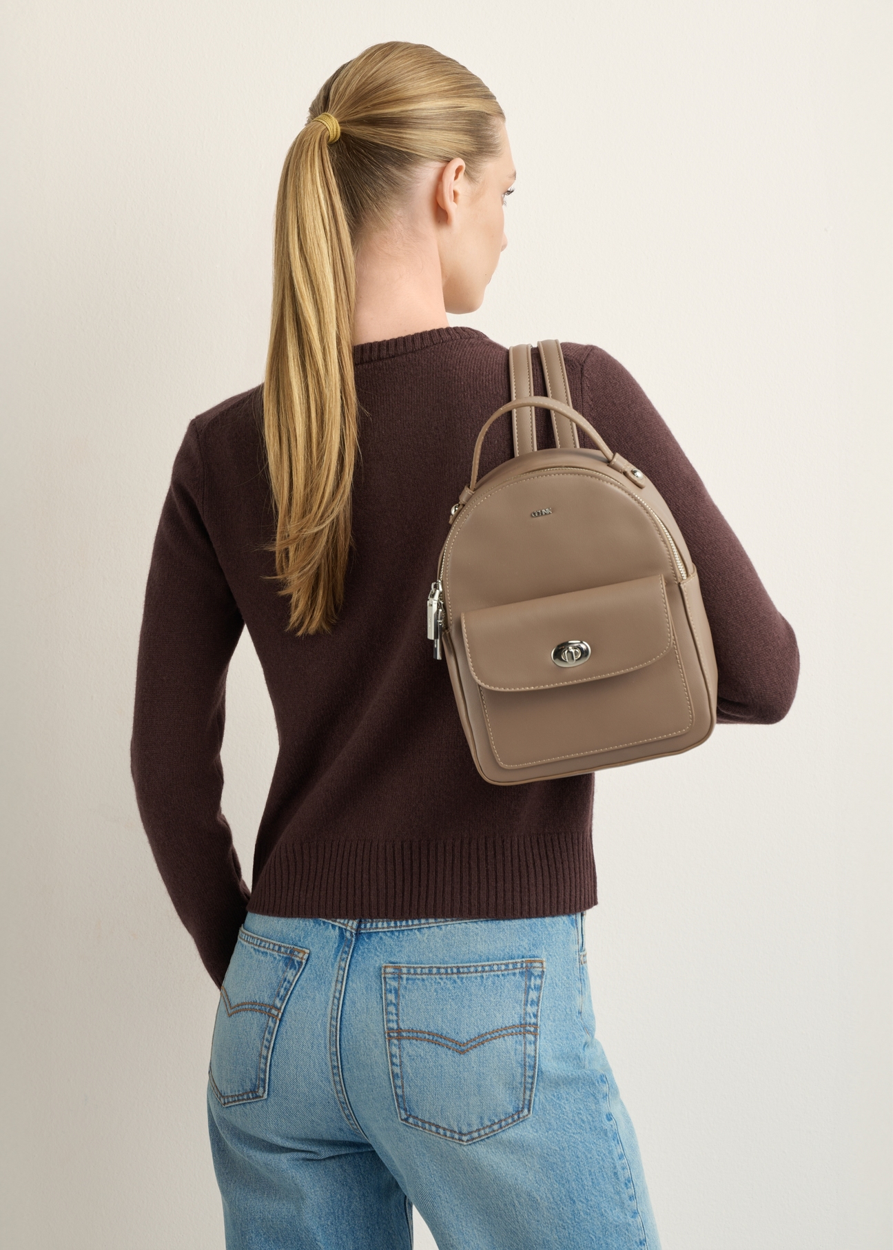 Small women's city backpack TOREC-1321-1K(Z26), front view of the product on a model. Half of the silhouette visible.