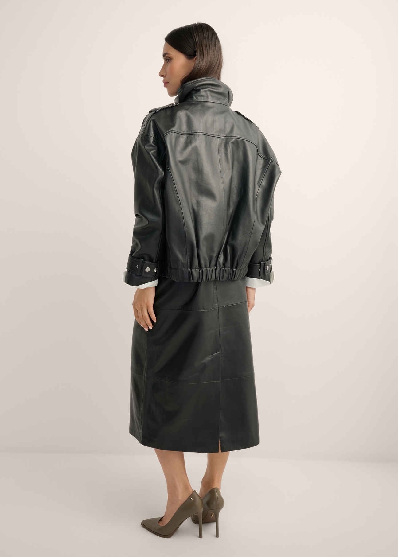 Black oversized leather jacket KURDS-0623-99(Z26), back view of the product on the model. Full body visible.
