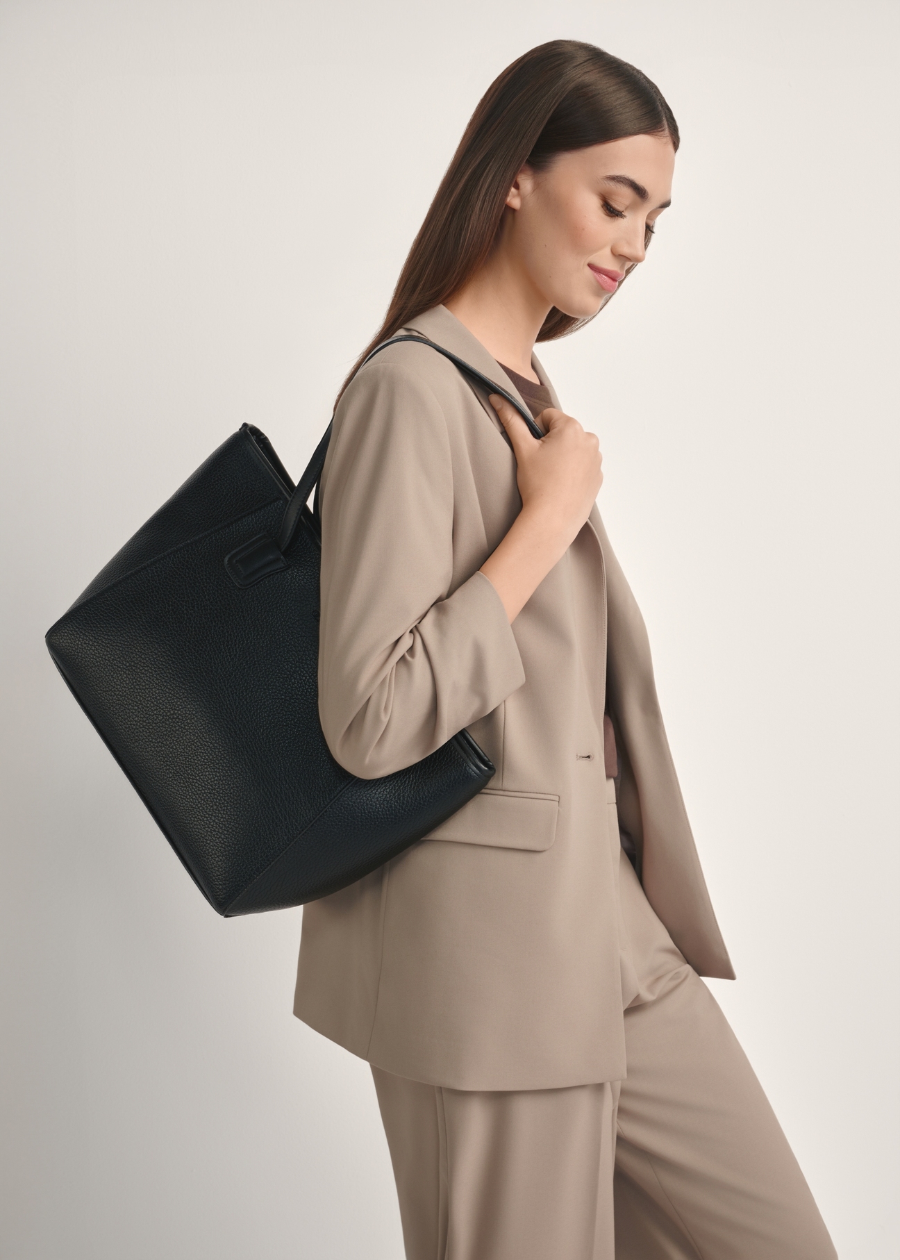 Black women's shopper bag TOREC-1162-99(W26), front view of the product on the model, half of the silhouette visible.