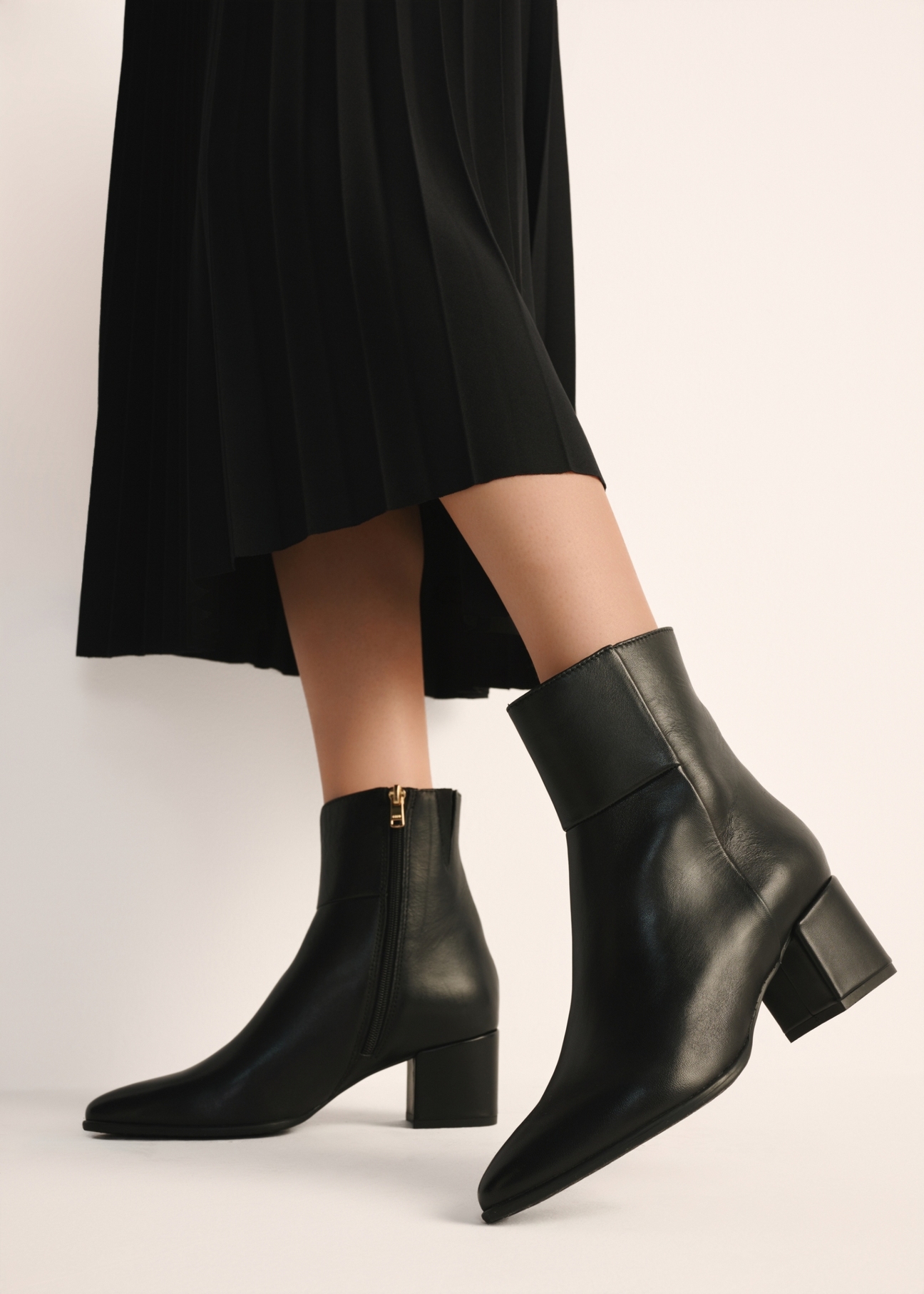 Women's leather ankle boots in black BUTYD-1186-99(Z25), product view on a model against a light background.