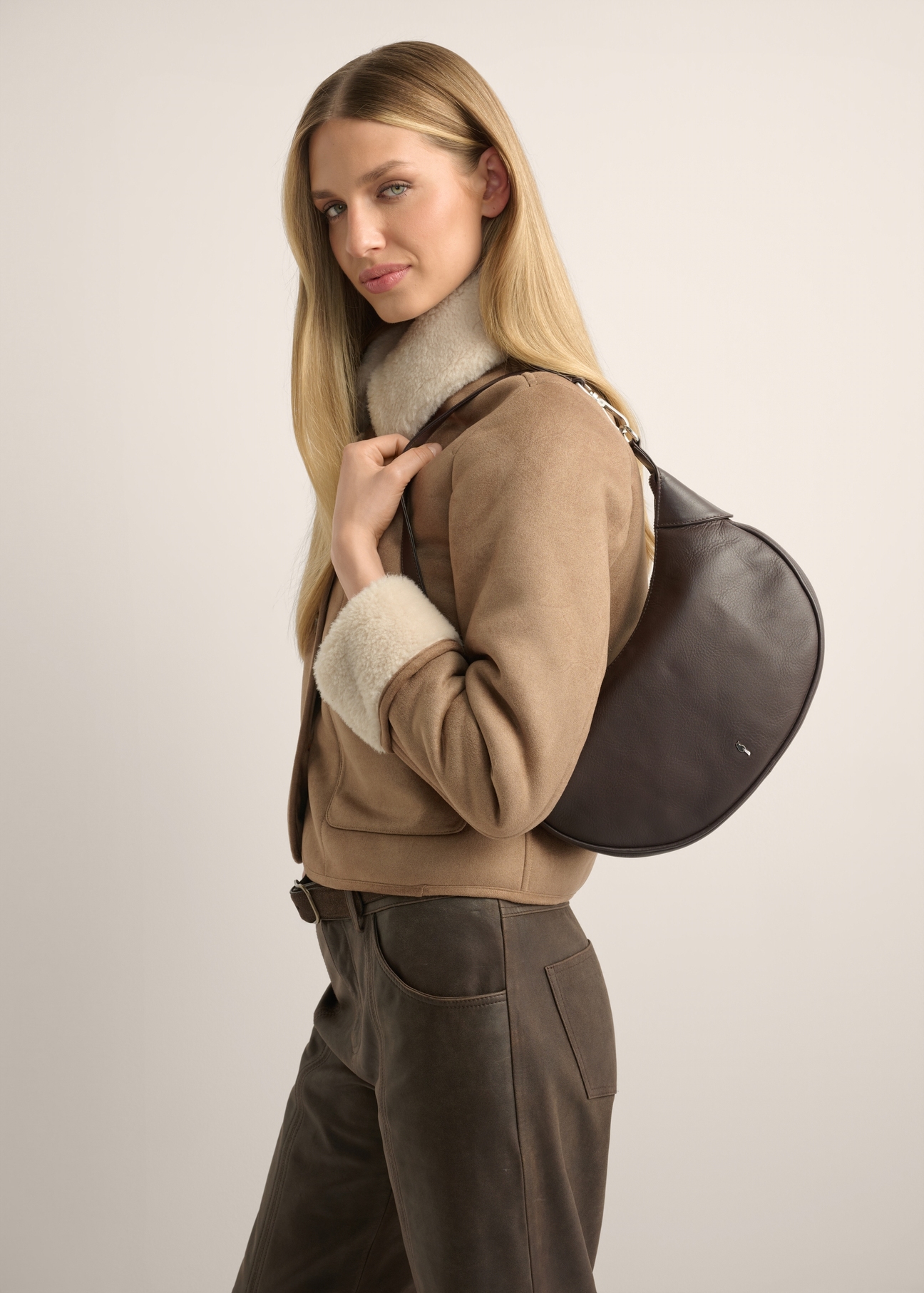 TORES-1318-1H(Z26), semi-circular brown women's shoulder bag. Front view of the product on a model. Half of the silhouette visible.