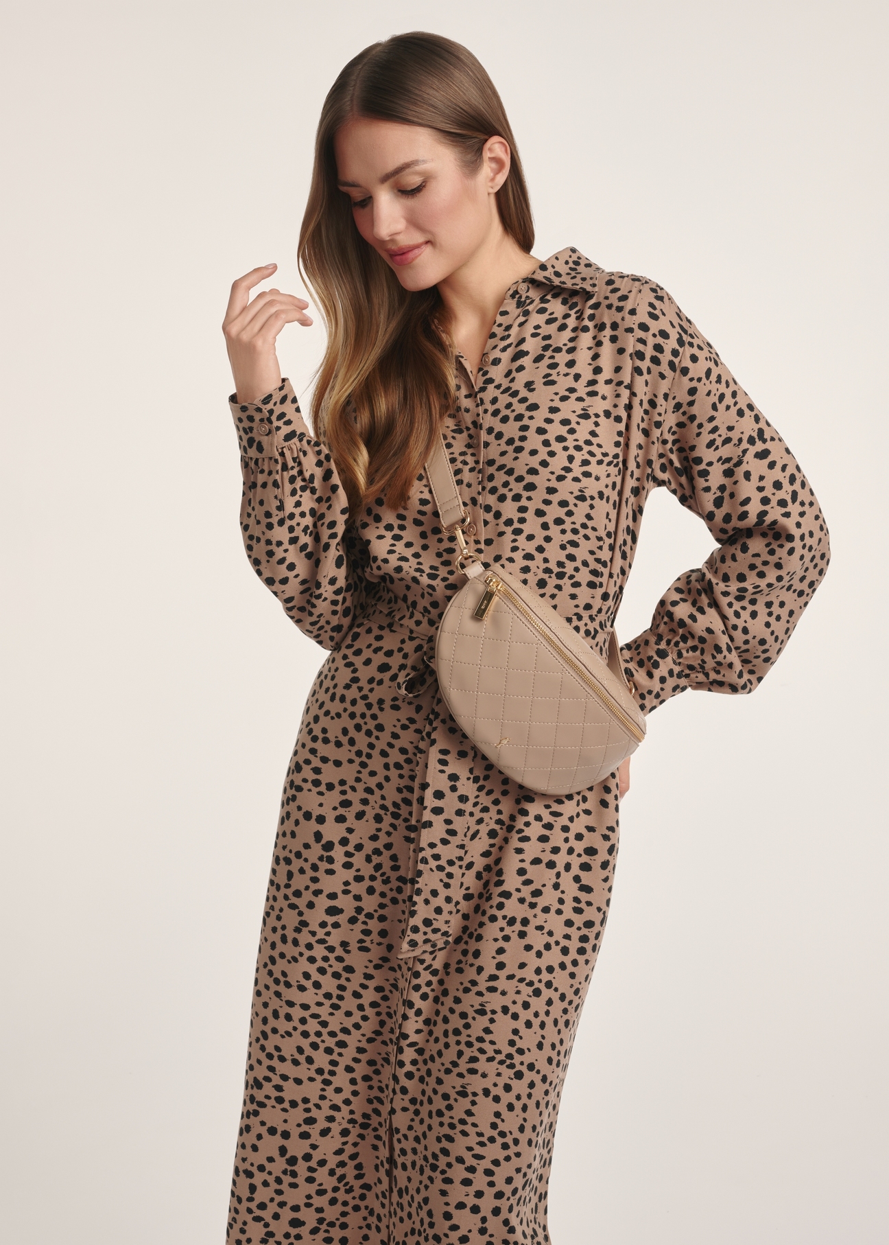 Quilted beige women's waist bag TOREC-0878B-81(Z25), front view of the product on the model, half of the silhouette visible.