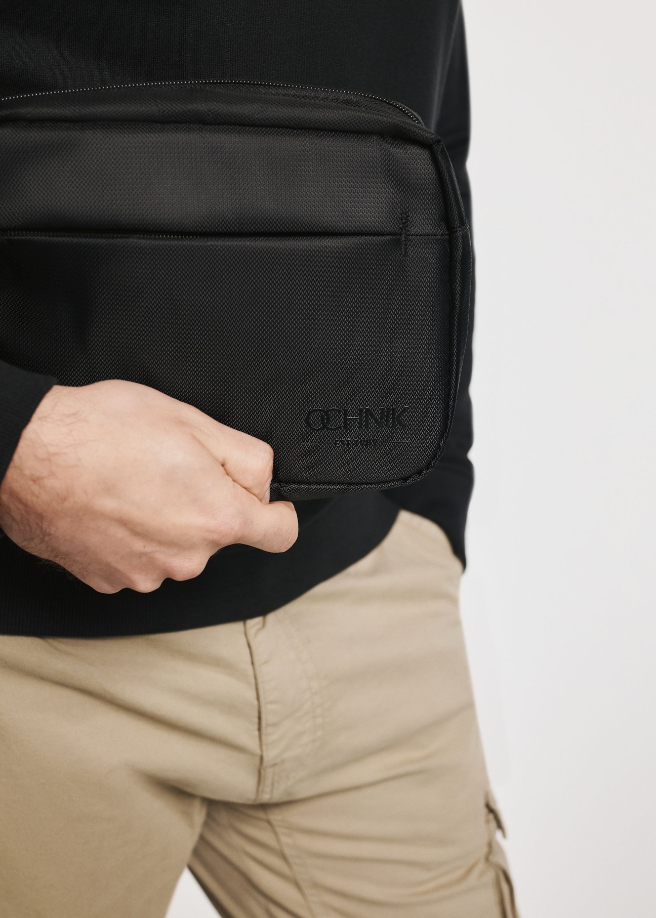 Black men's cosmetic bag TORMS-0267C-99(Z25), close-up of the product in the model's hand.