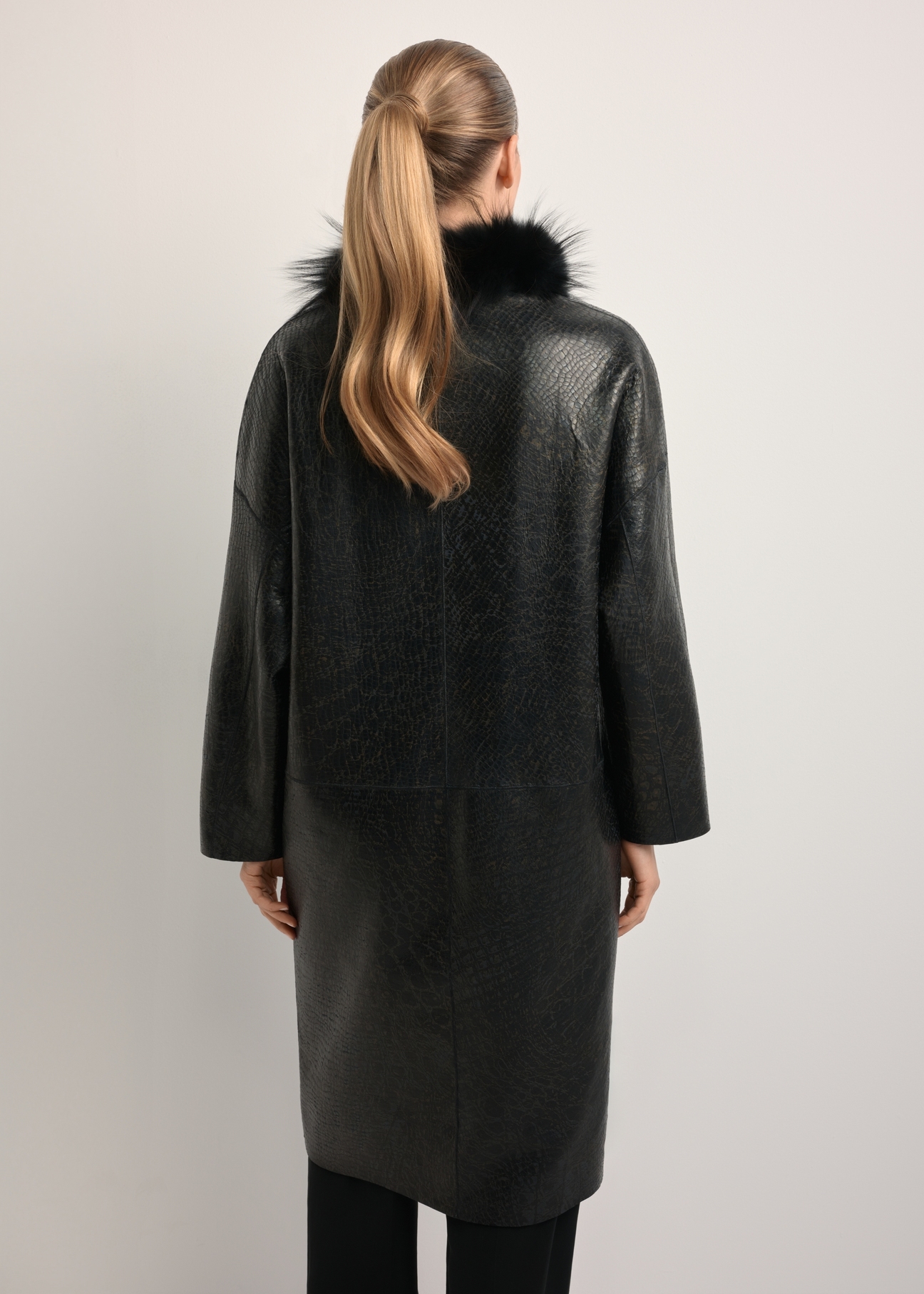 Black leather double-sided women's sheepskin coat KOZDS-0093-1396(Z25), back view of the product on the model. Half of the silhouette visible.