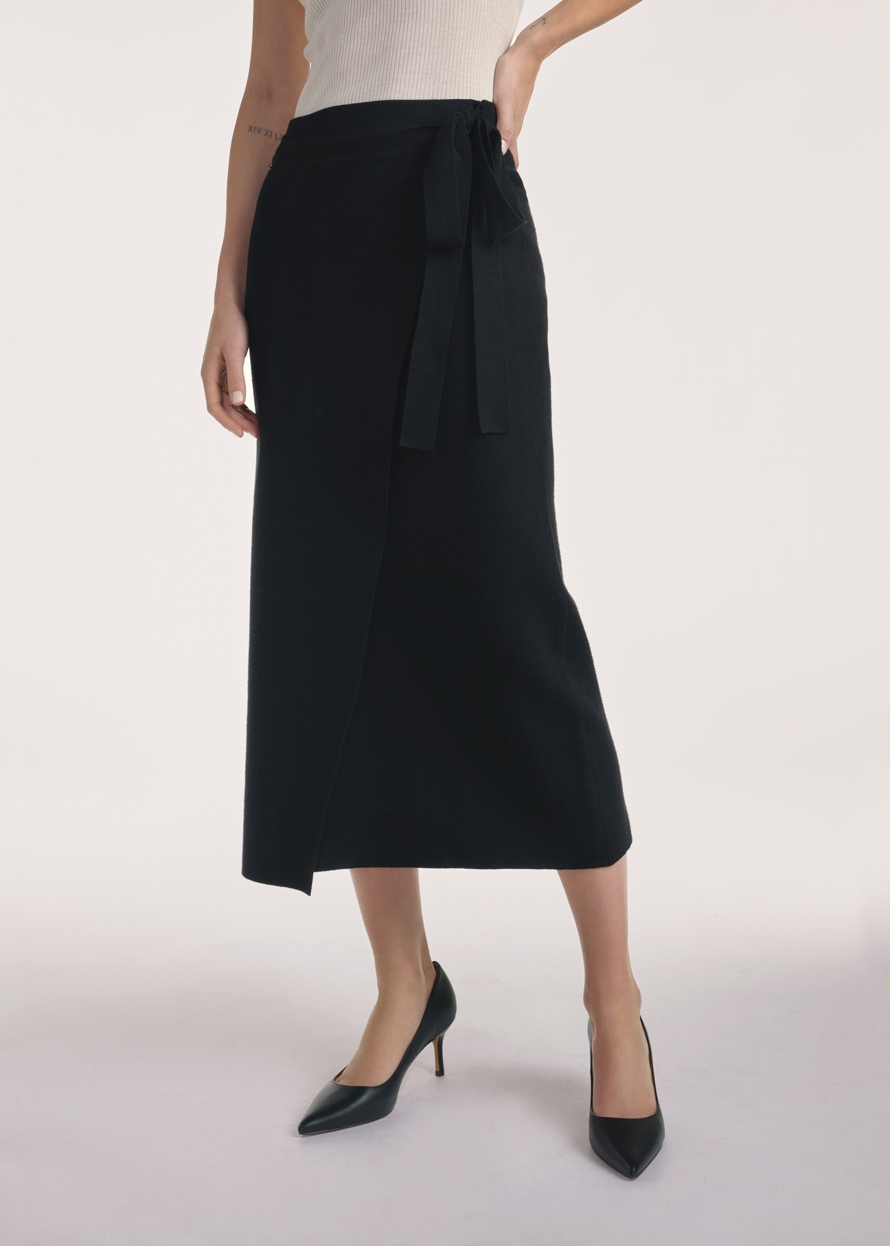 Black midi skirt SPCDT-0114-99(Z25), front view of the product on the model, half of the silhouette visible.