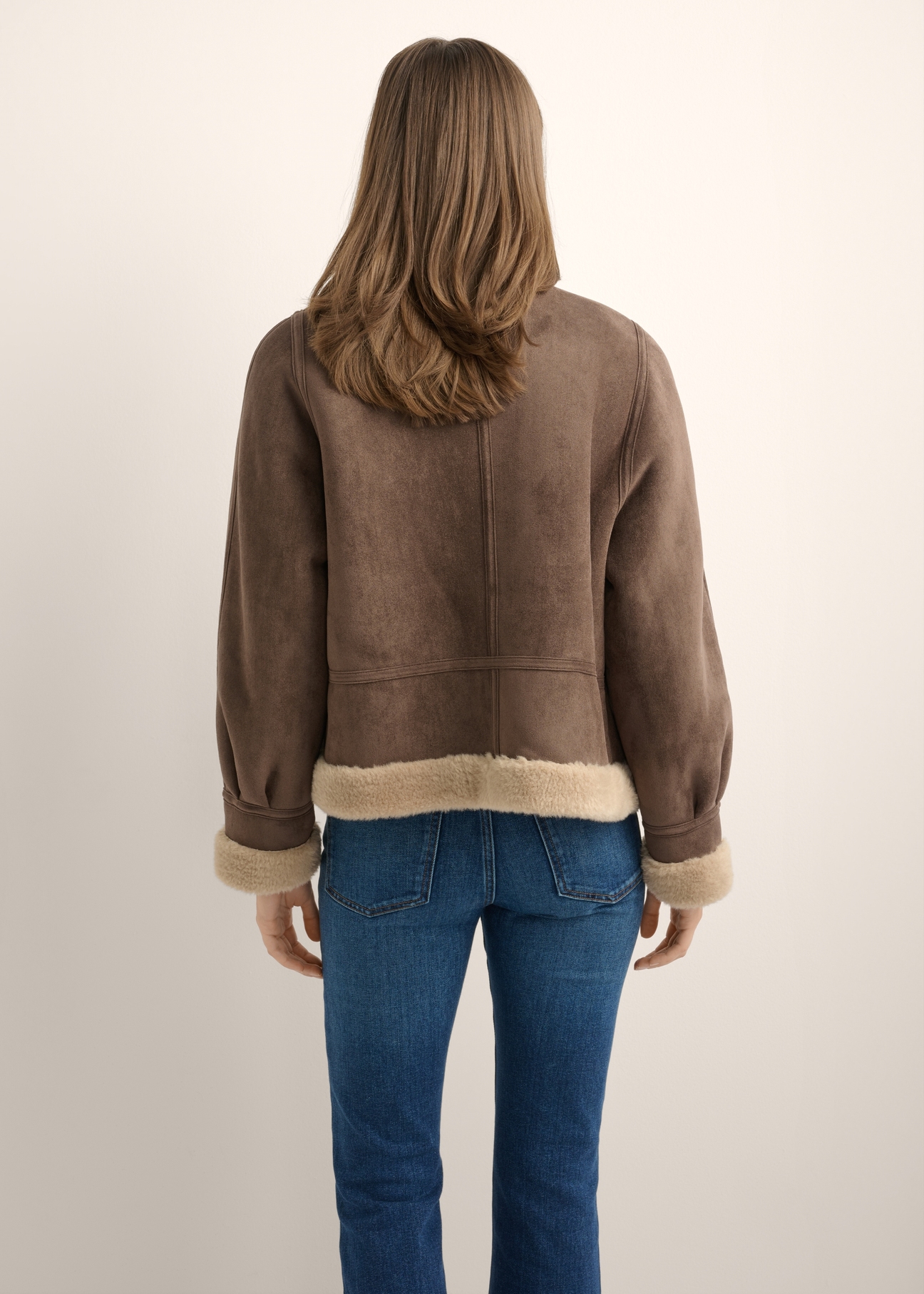 Women's dark brown short sheepskin coat KOZDP-0018-1I(Z26), product view from the back on the model. Half of the silhouette visible.
