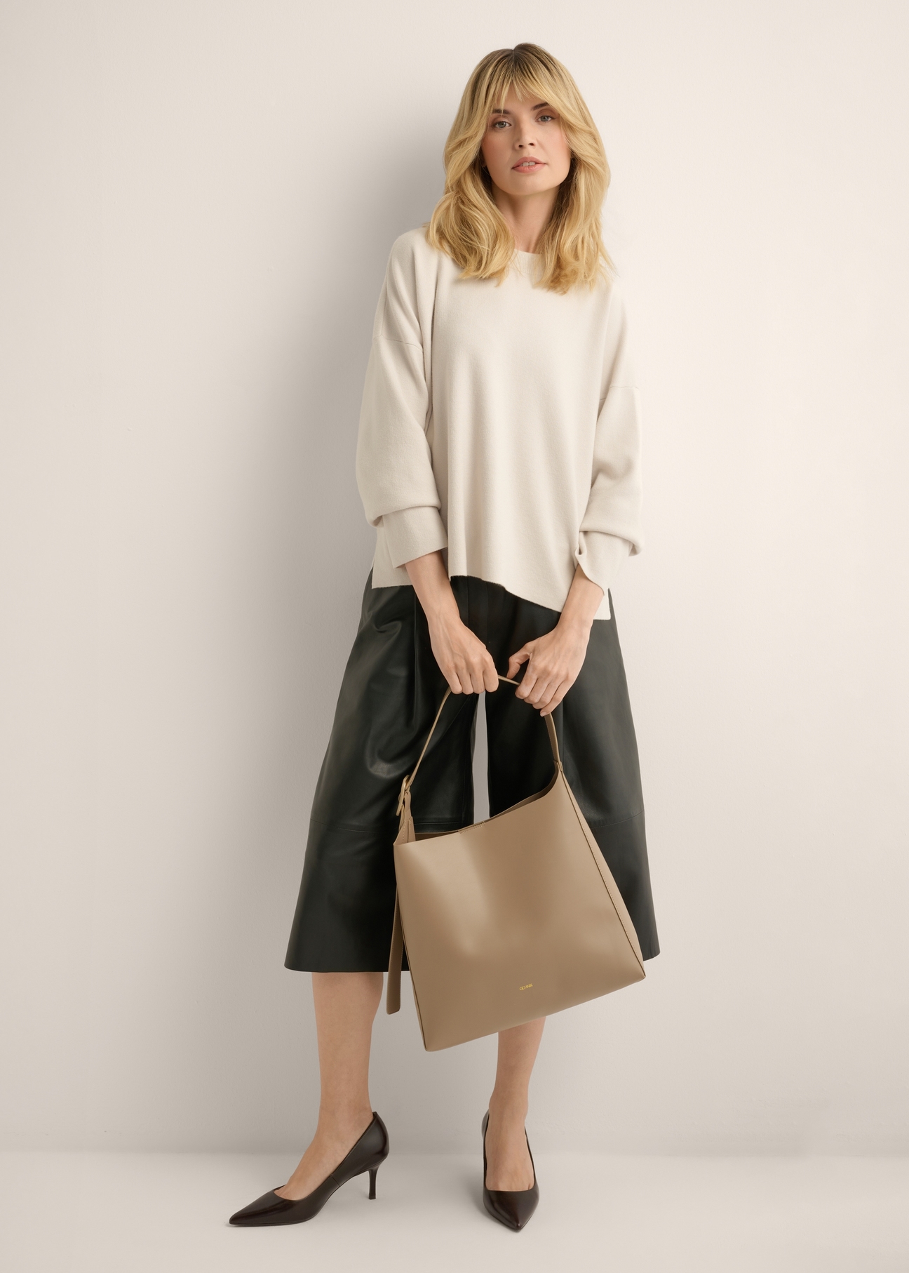 Large women's shoulder bag in cool beige TOREC-1337-1K(Z26), view of the product in the model's hands. Full body visible.