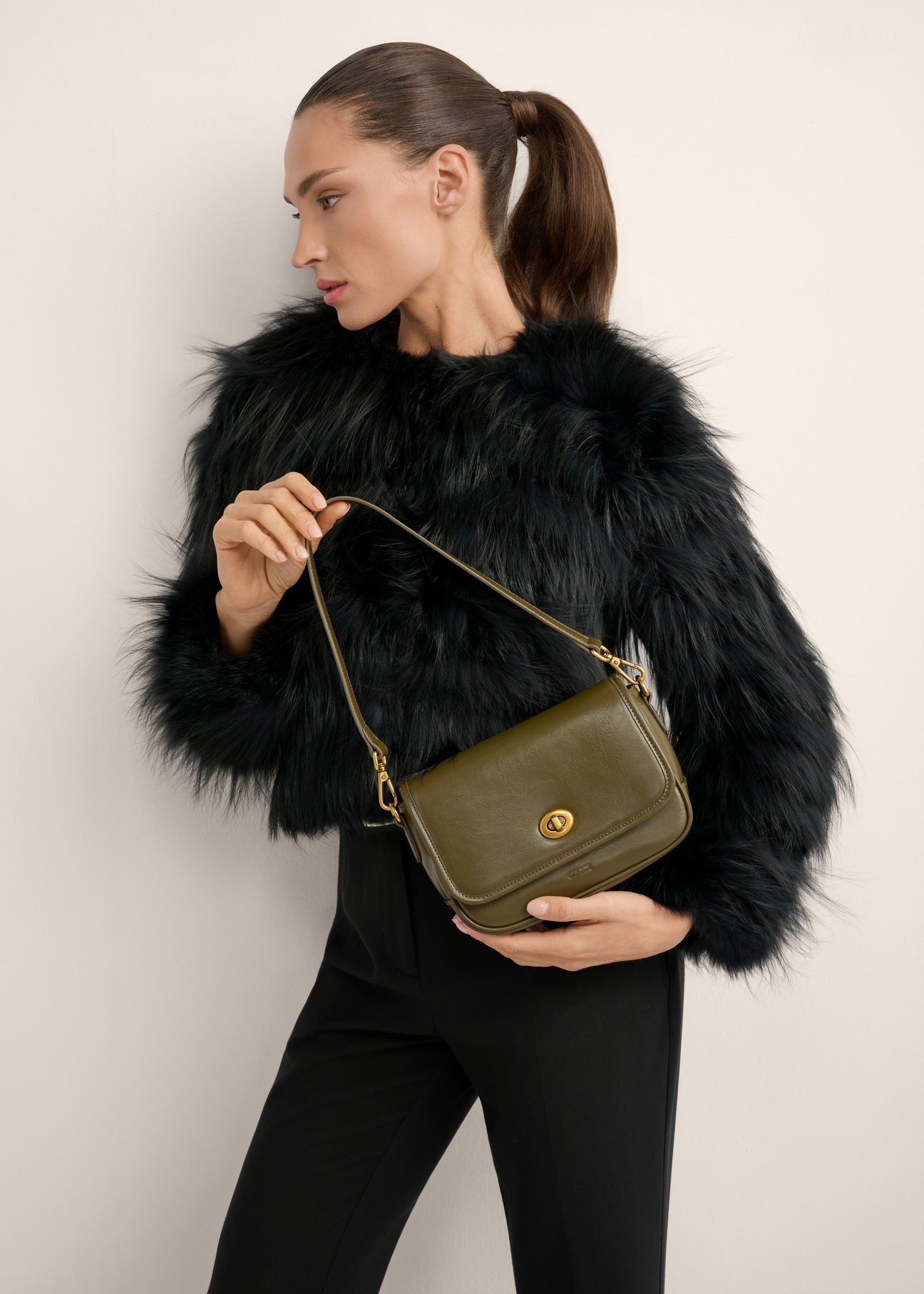 Small women's khaki handbag TOREC-1249-8D(Z26), product view in model's hand. Half of silhouette visible.