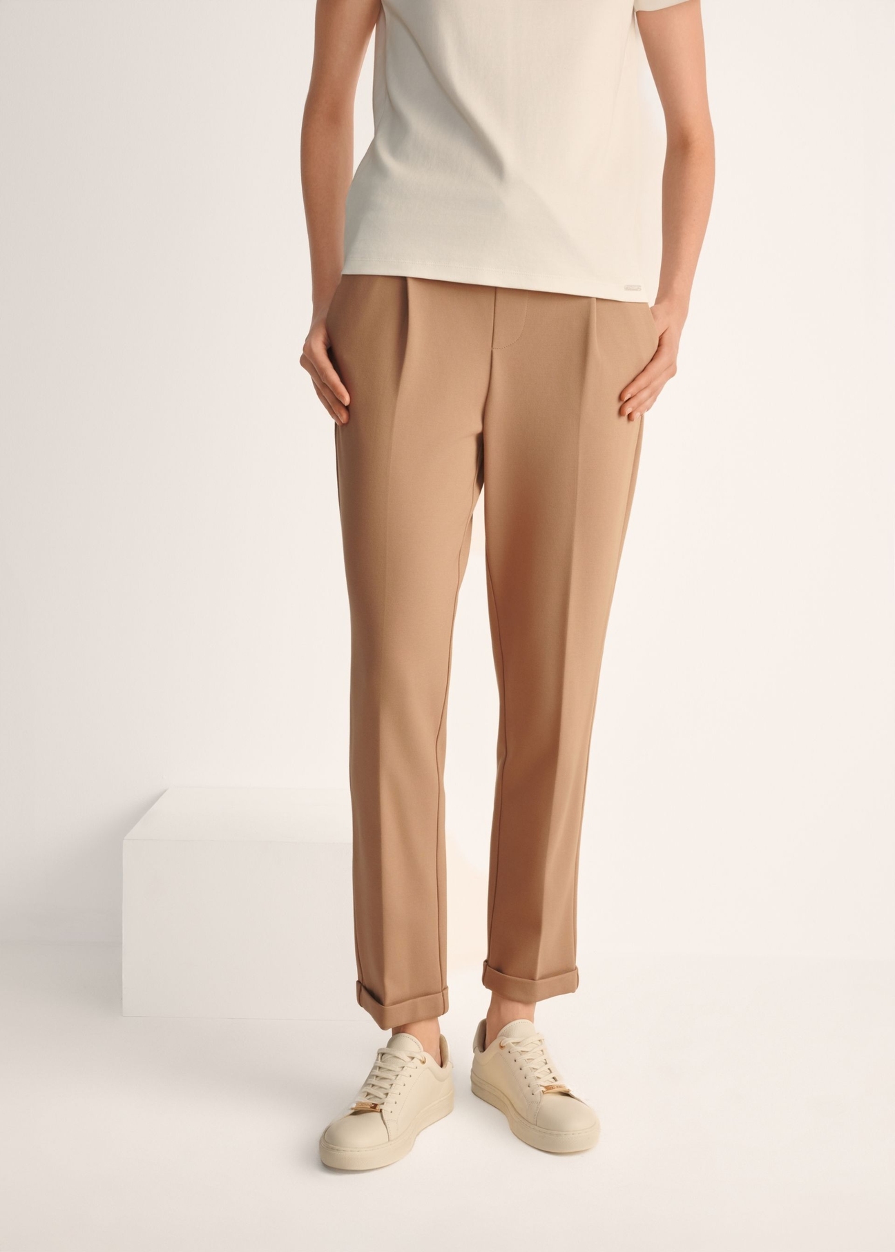 Women's white leather sneakers BUTYD-1068-0B(W26), product view on model's feet against a light background.