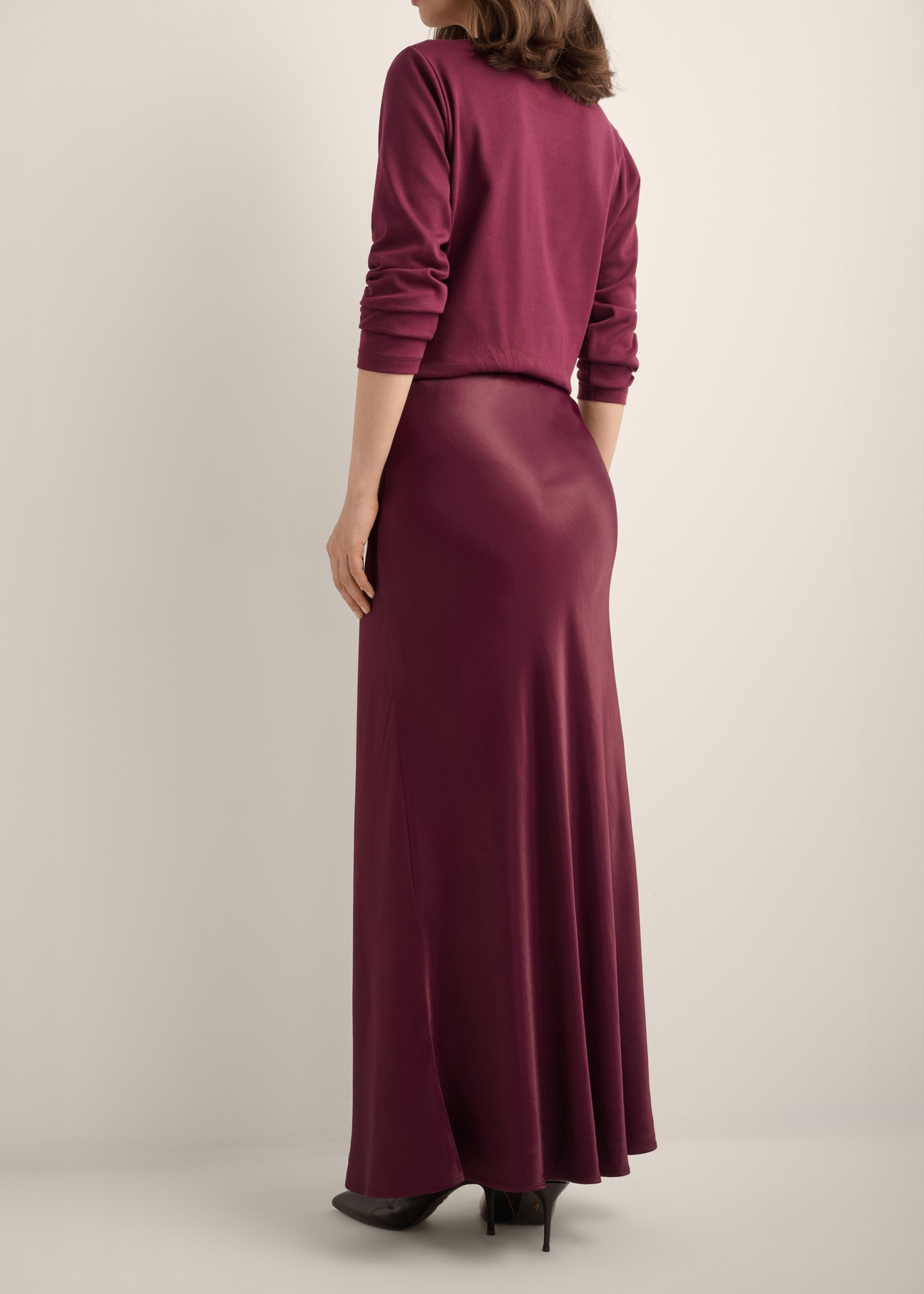 Burgundy long women's skirt SPCDT-0117-4D(Z26), product view from the back on the model. Half of the silhouette visible.