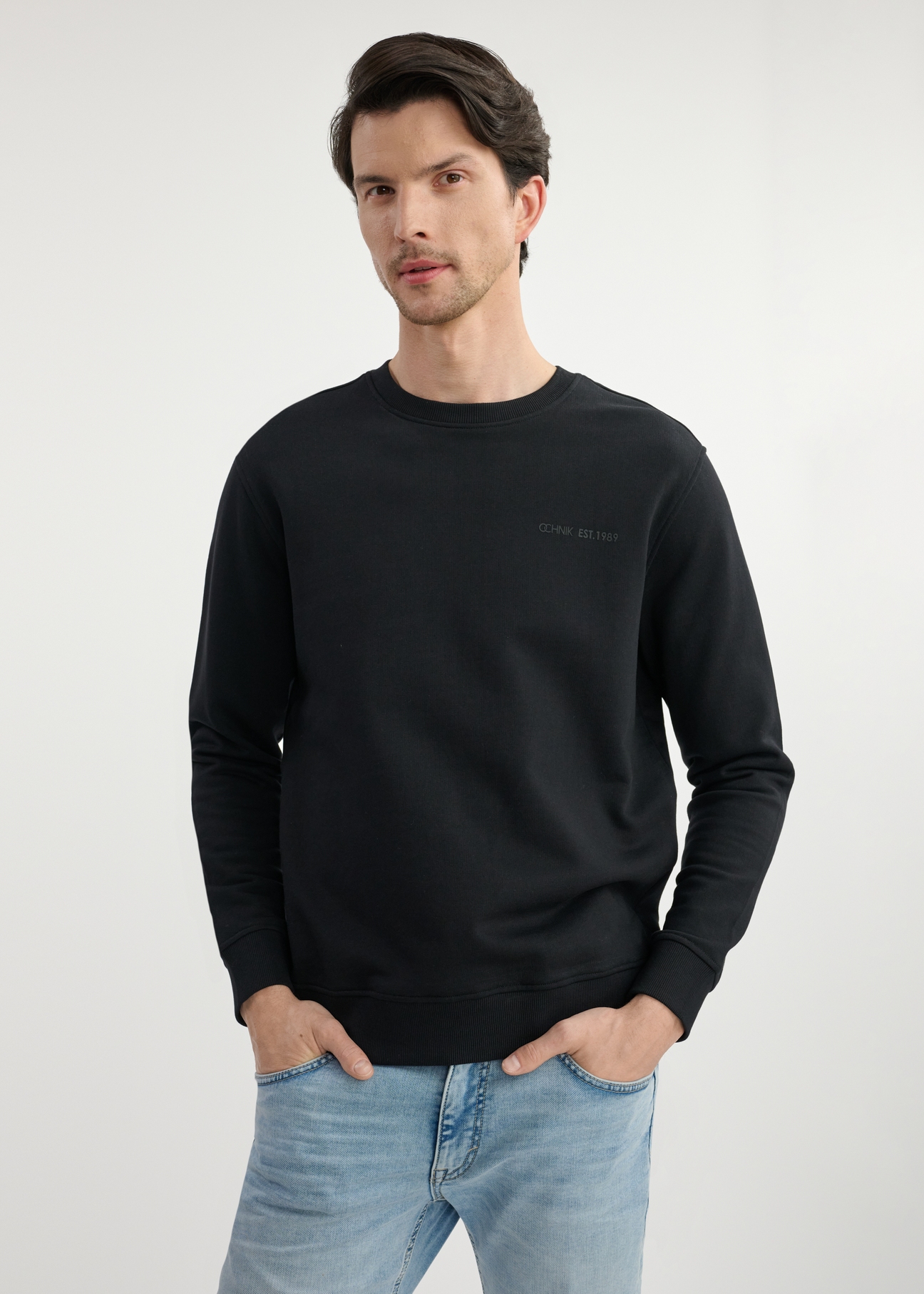 Black men's sweatshirt without hood BLZMT-0070-99(W25) - front view on the model on a white background. Half of the silhouette visible.